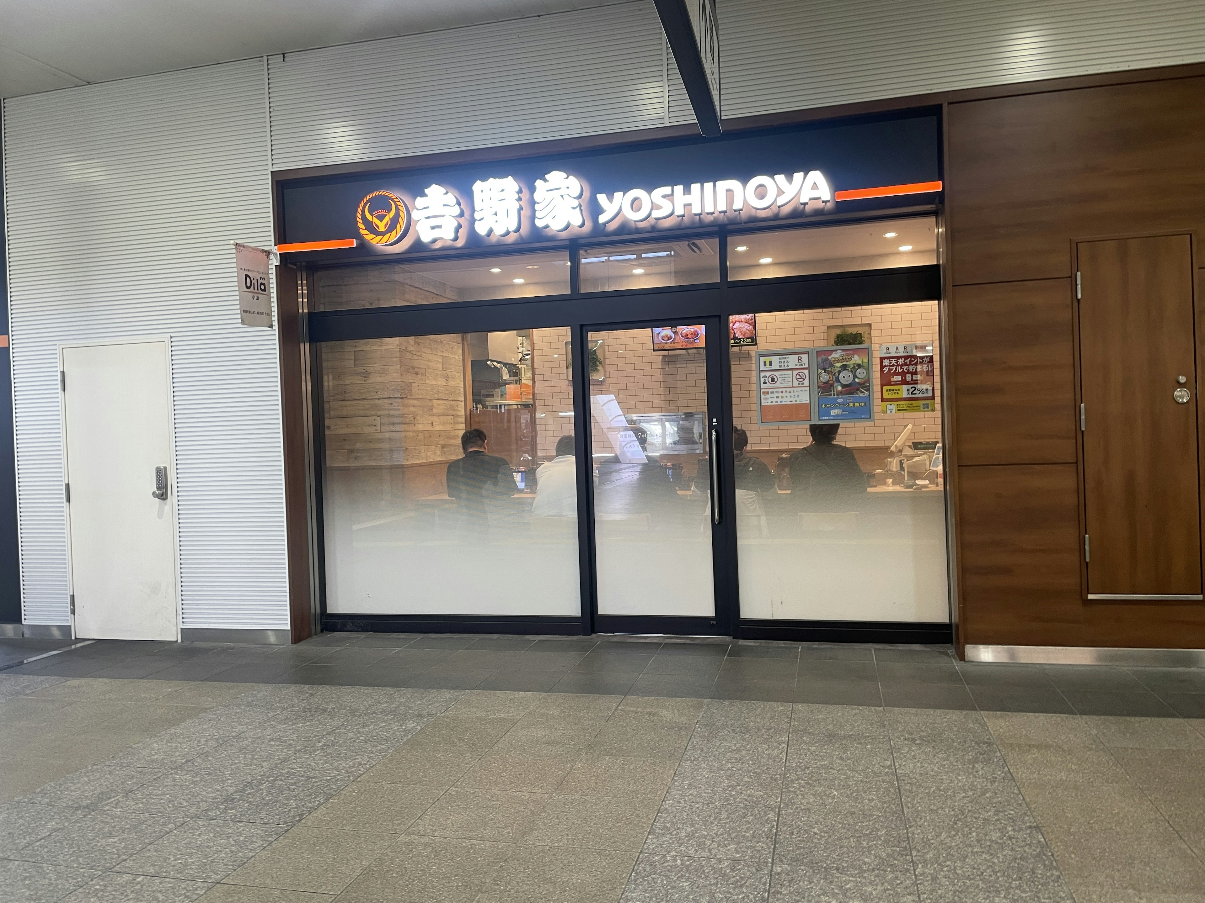 Außenansicht des Restaurants Yoshinoya mit heller Beleuchtung und modernem Design