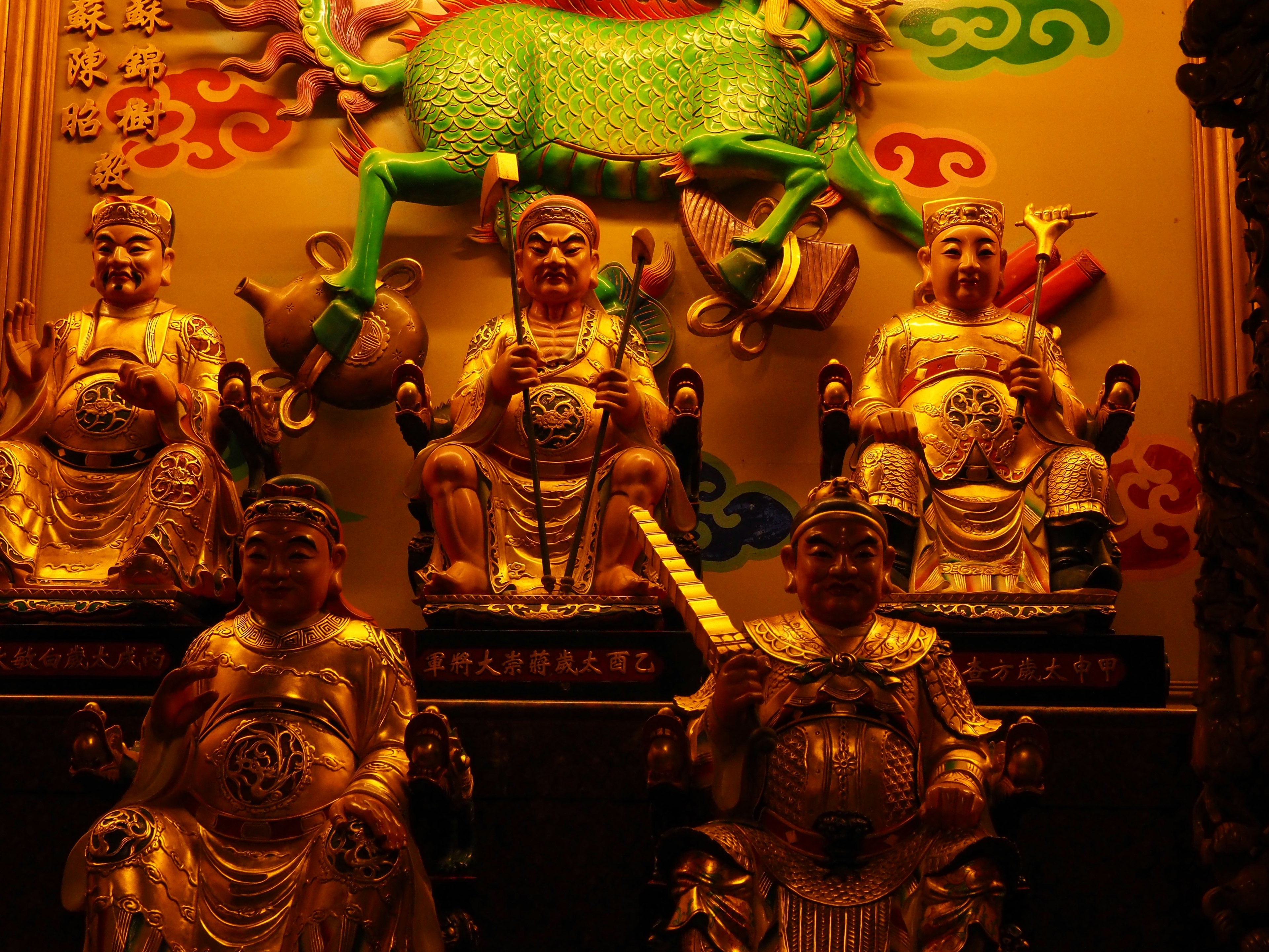 Interior view of a temple featuring golden deity statues