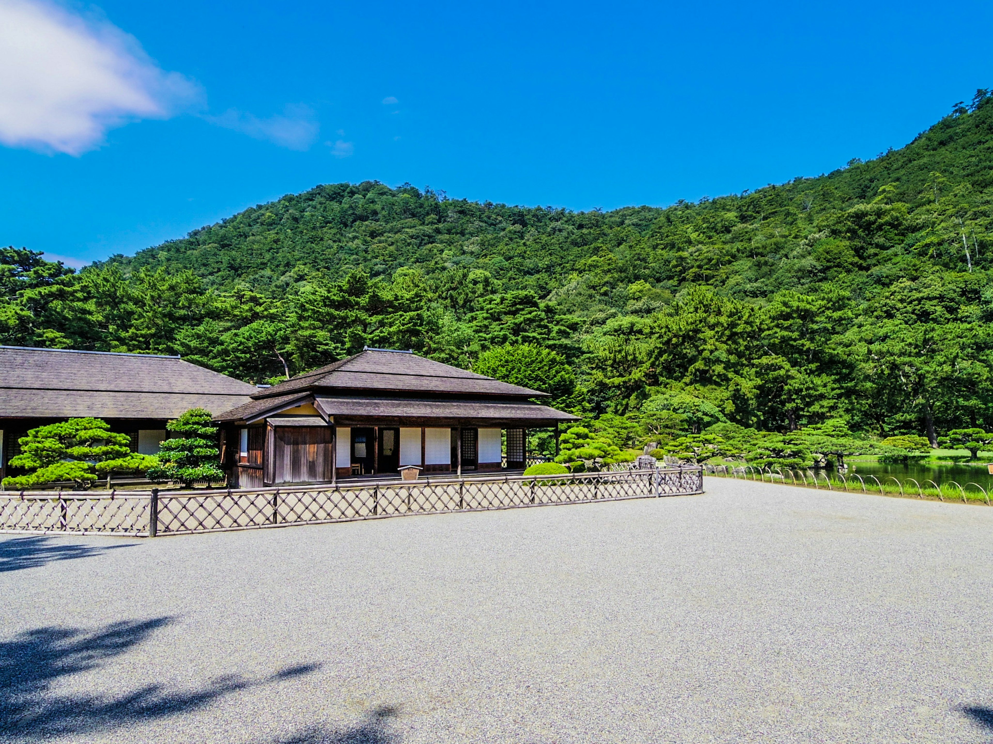 緑豊かな山々に囲まれた伝統的な日本家屋の風景