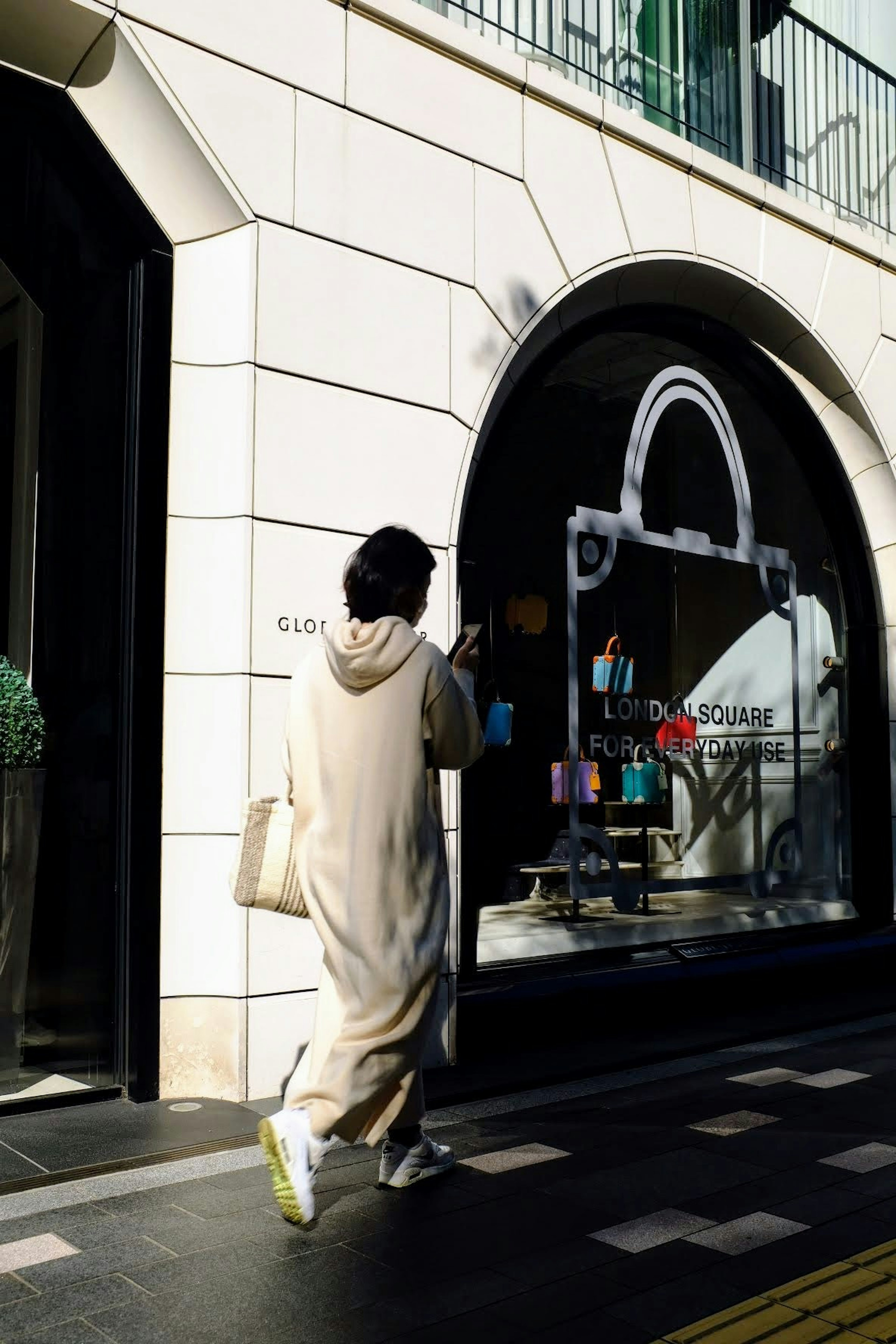 Una persona con una túnica blanca caminando frente a una tienda