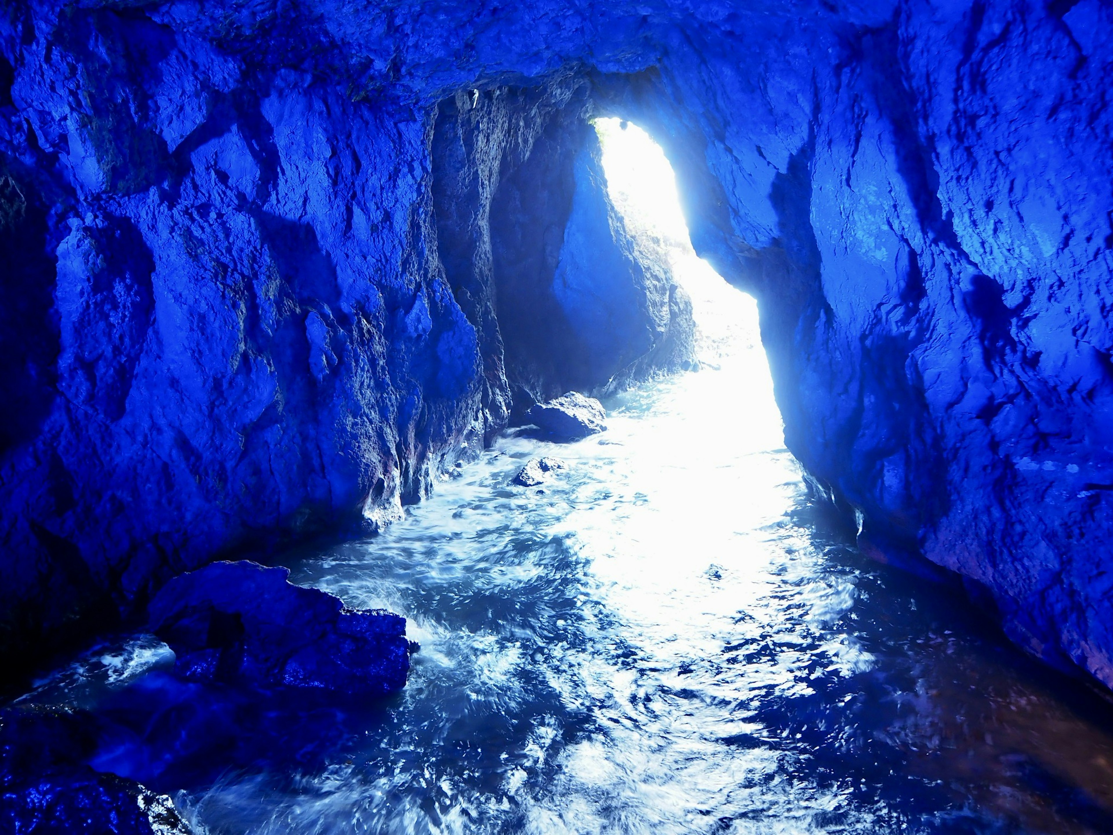 À l'intérieur d'une grotte bleue avec de l'eau scintillante et de la lumière