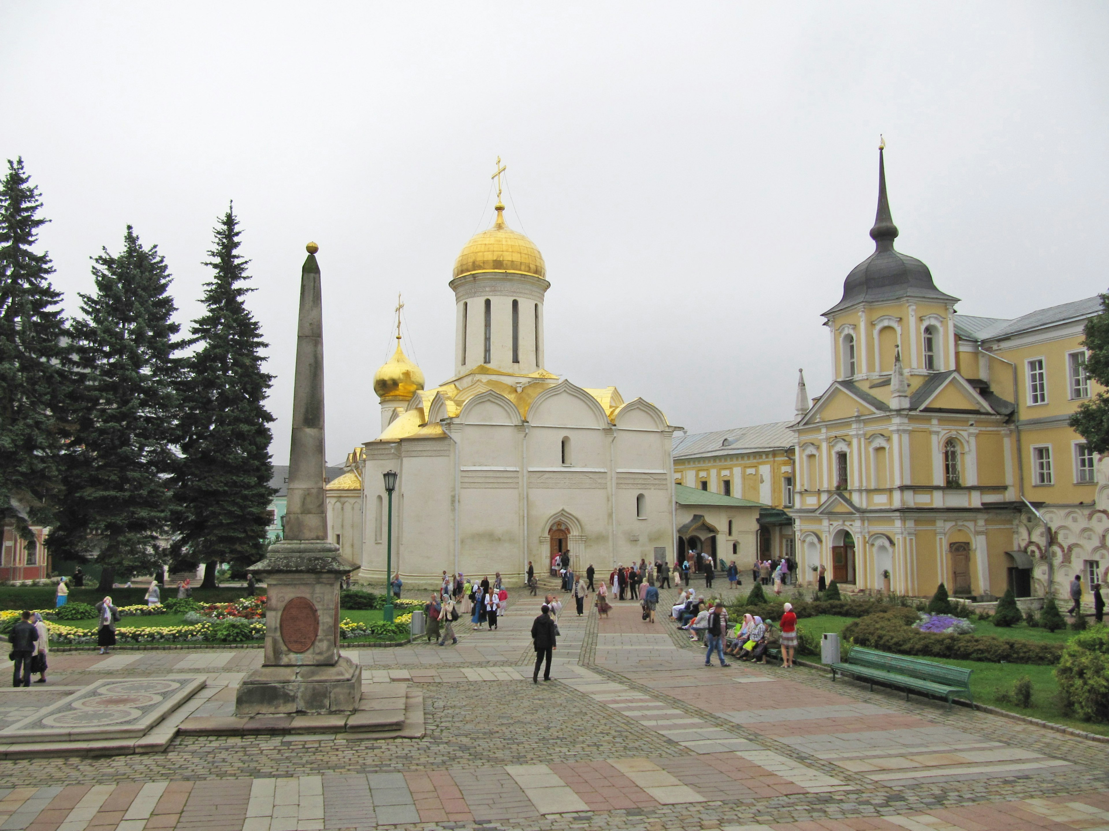 Scenic view of a square featuring a church with golden domes and historic buildings