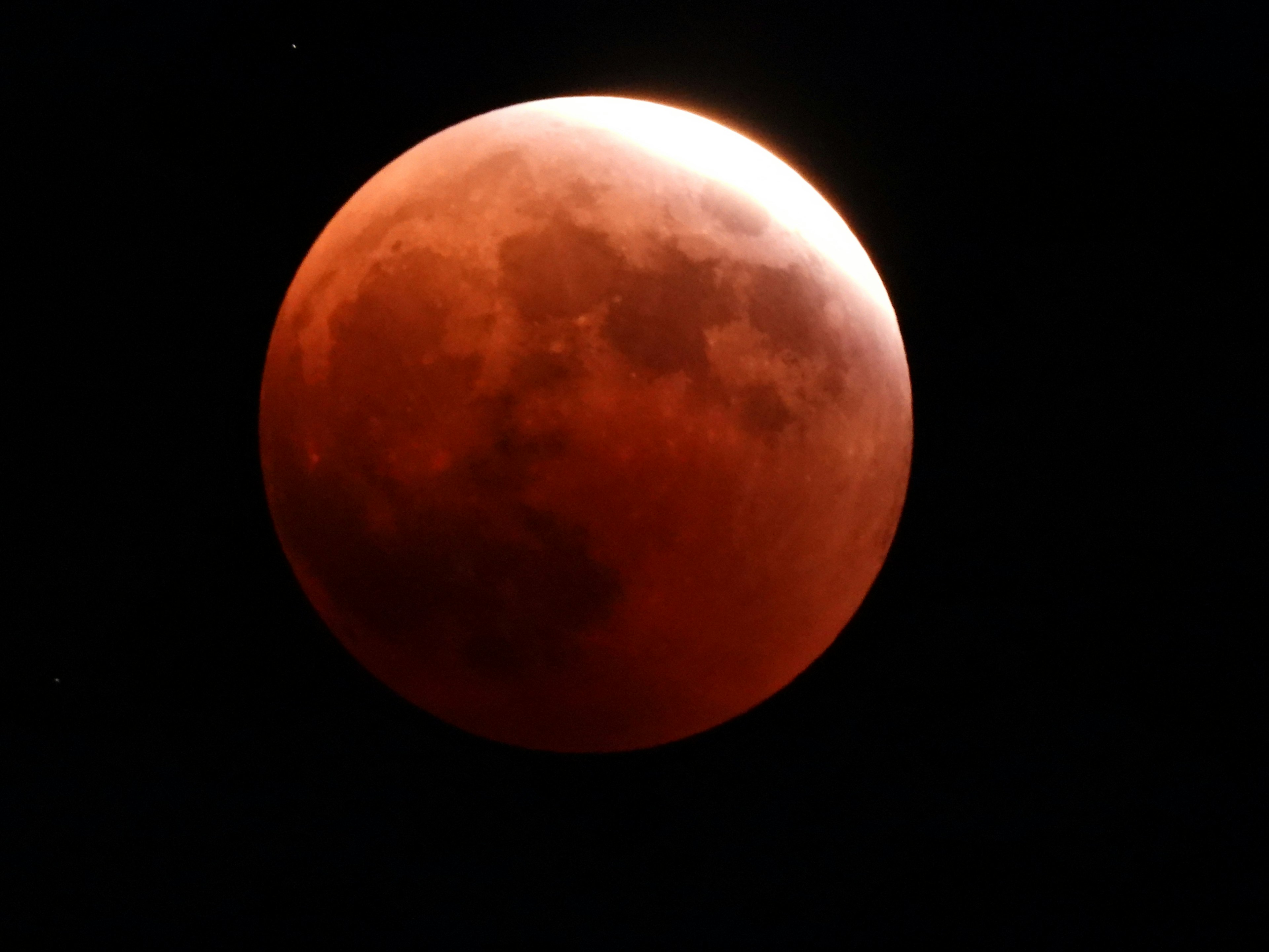 Detailed image of a red moon during a partial eclipse