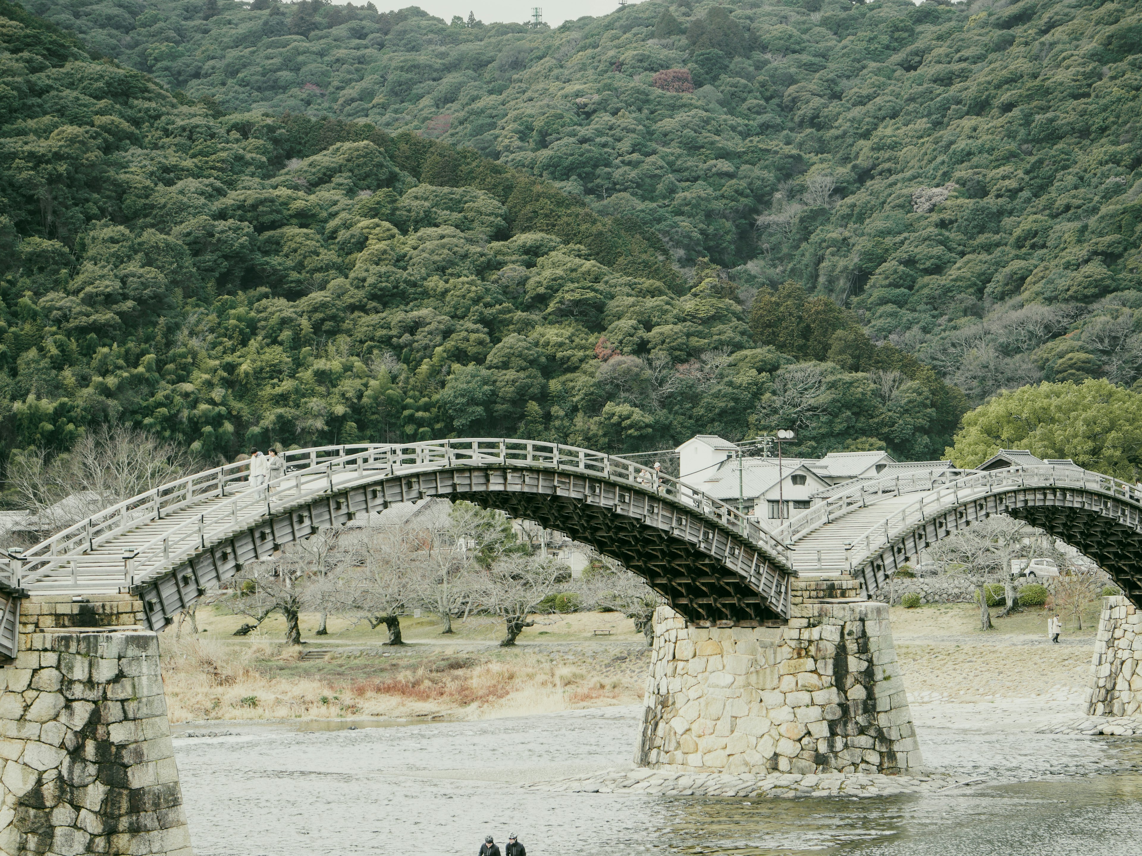 Beautiful arched bridge spanning over a river with lush green hills in the background