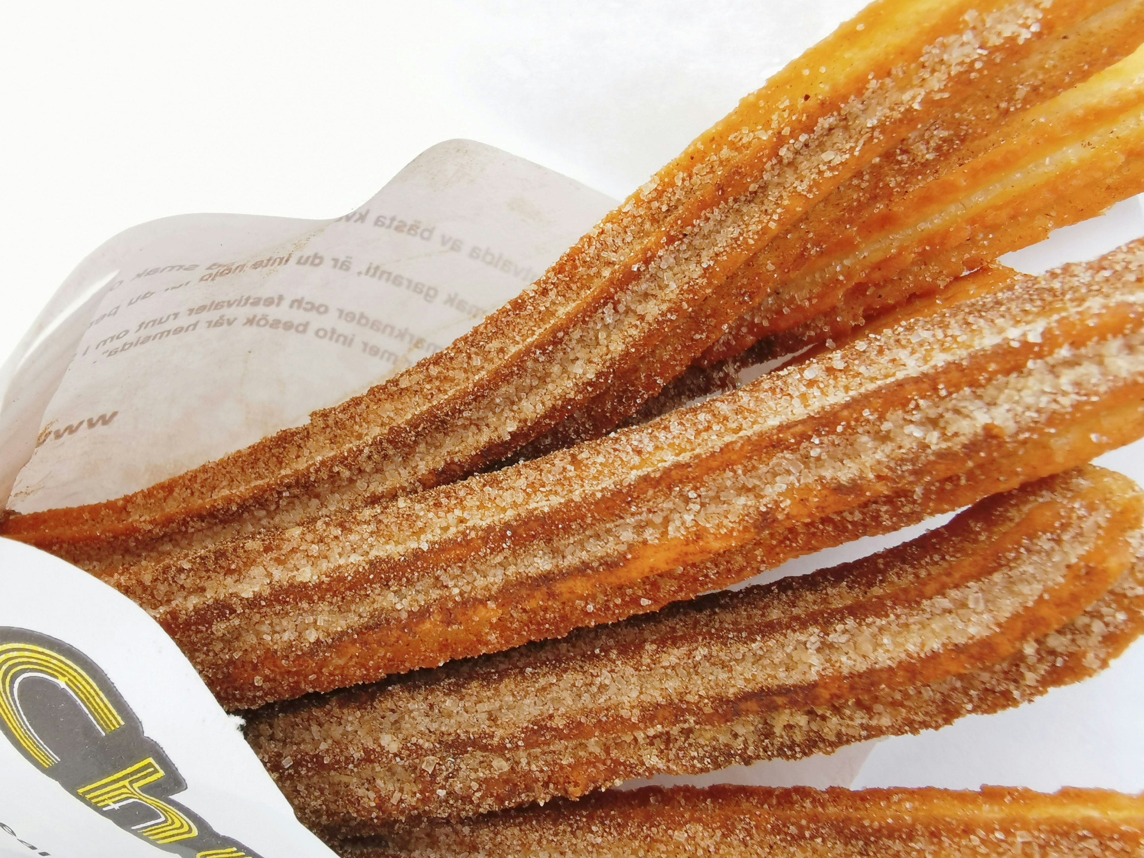 Frittierte Churros in Karamellfarbe mit knuspriger Textur und Zuckerguss