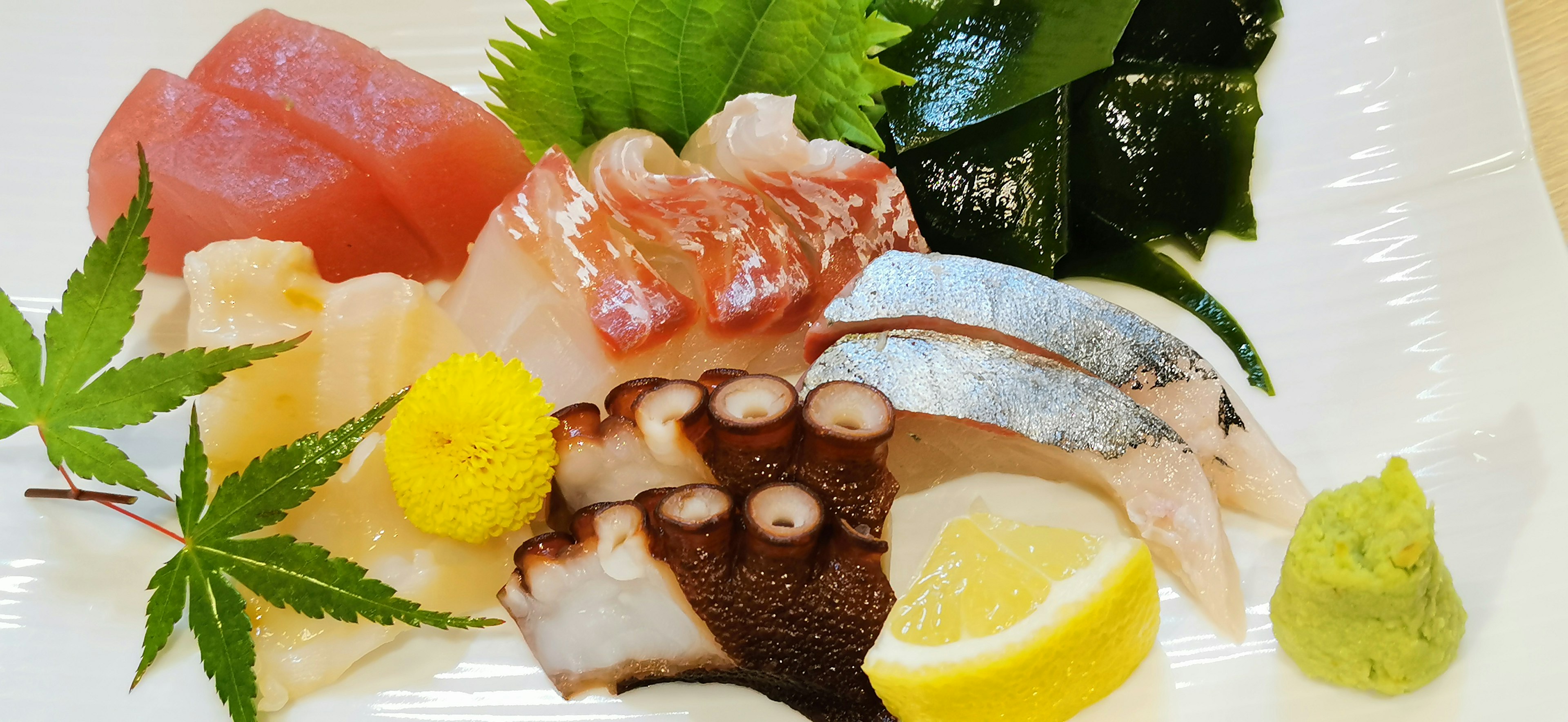 Piring sushi segar dengan berbagai jenis ikan dan hiasan berwarna