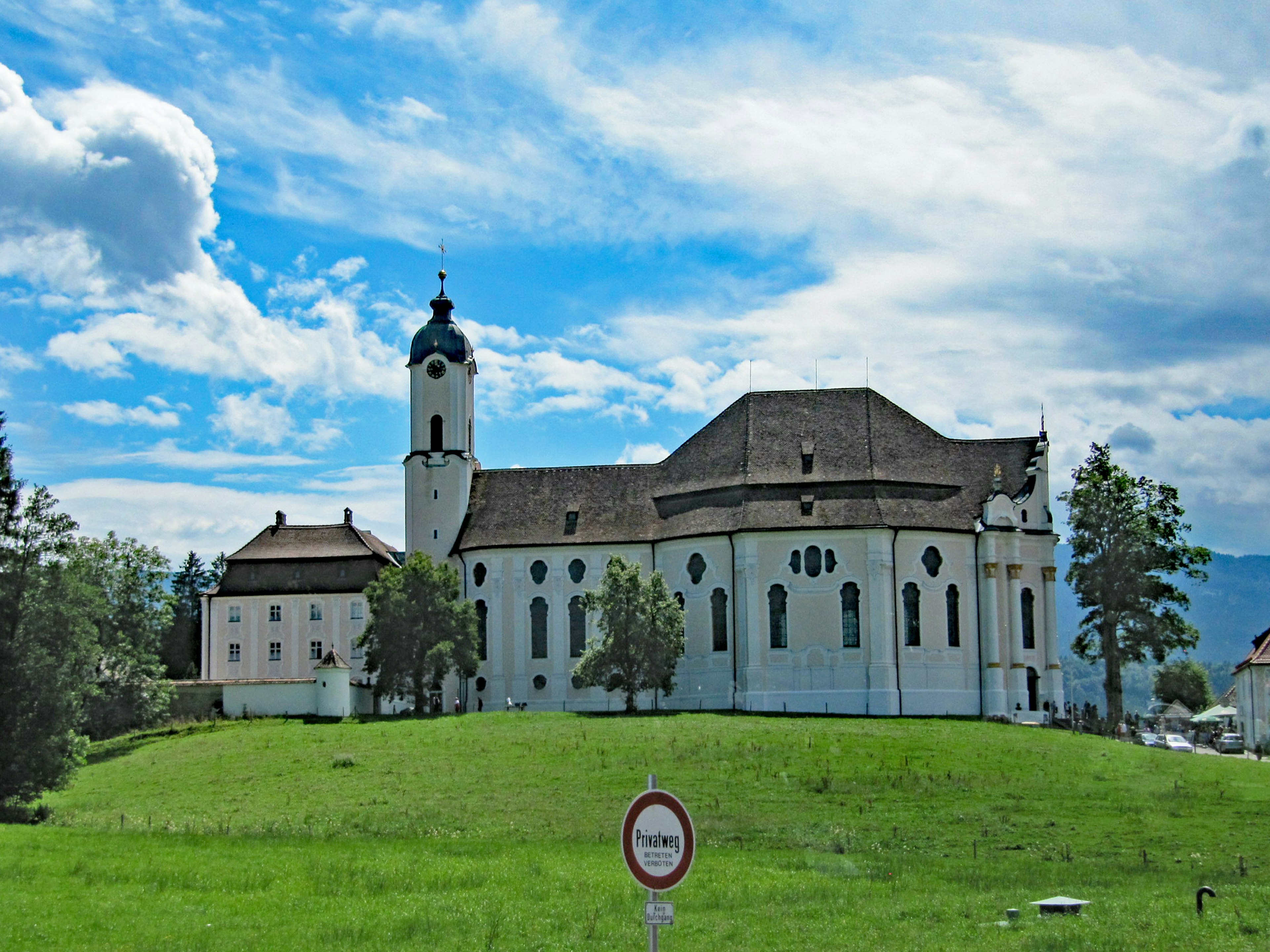 White church with a blue sky landscape surrounded by green grass