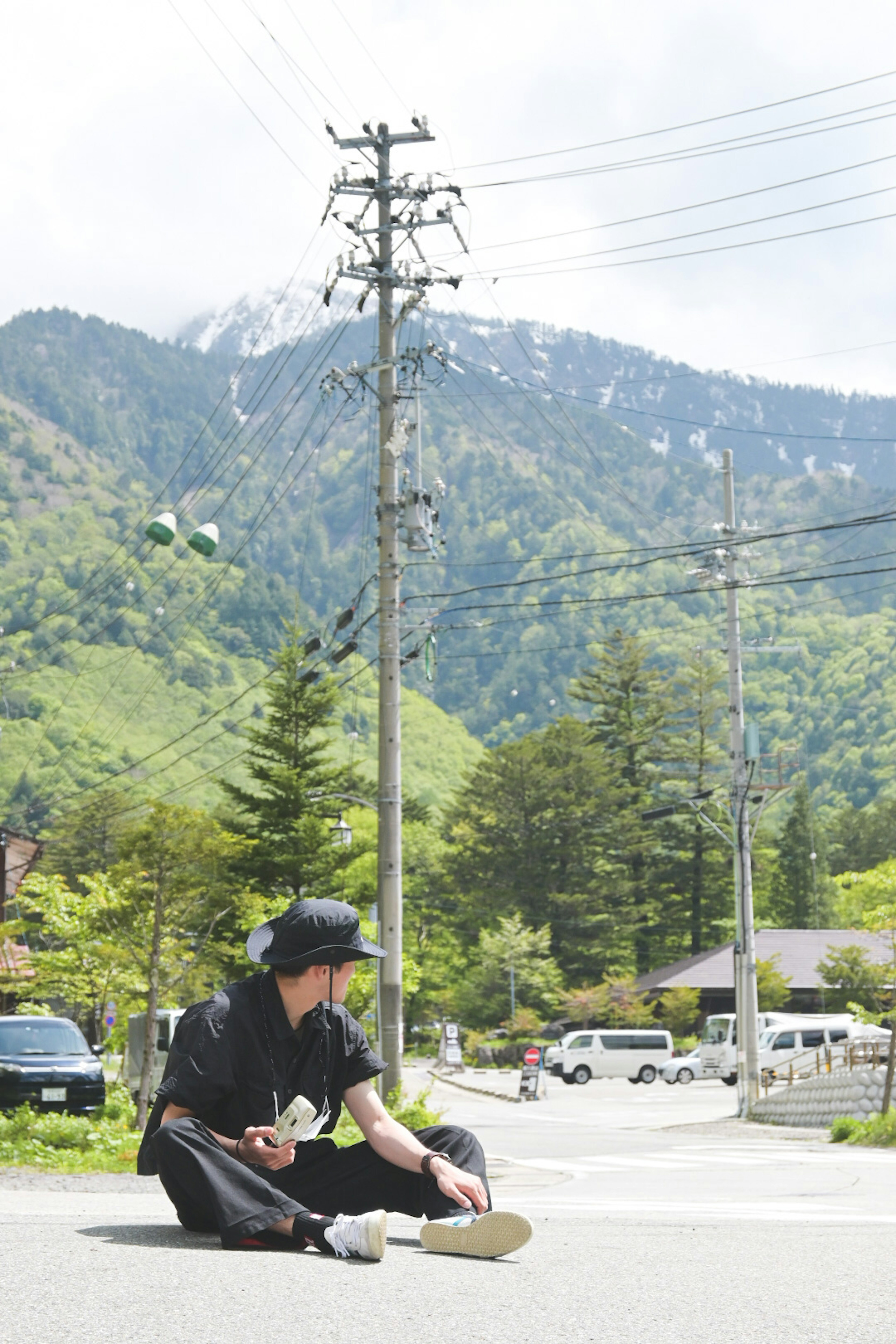 山を背景にした道路に座っている人物