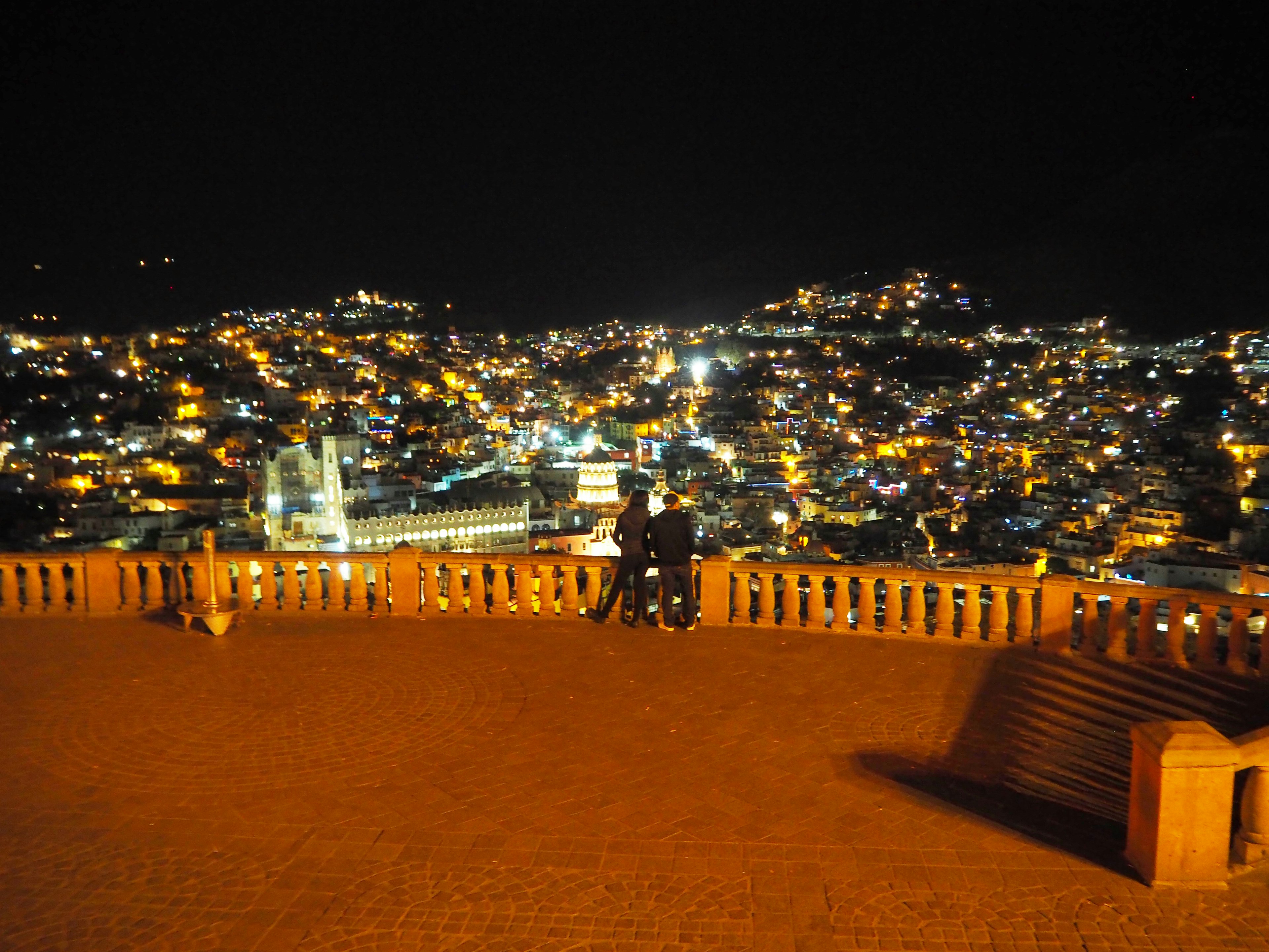 Coppia in piedi con skyline cittadino di notte