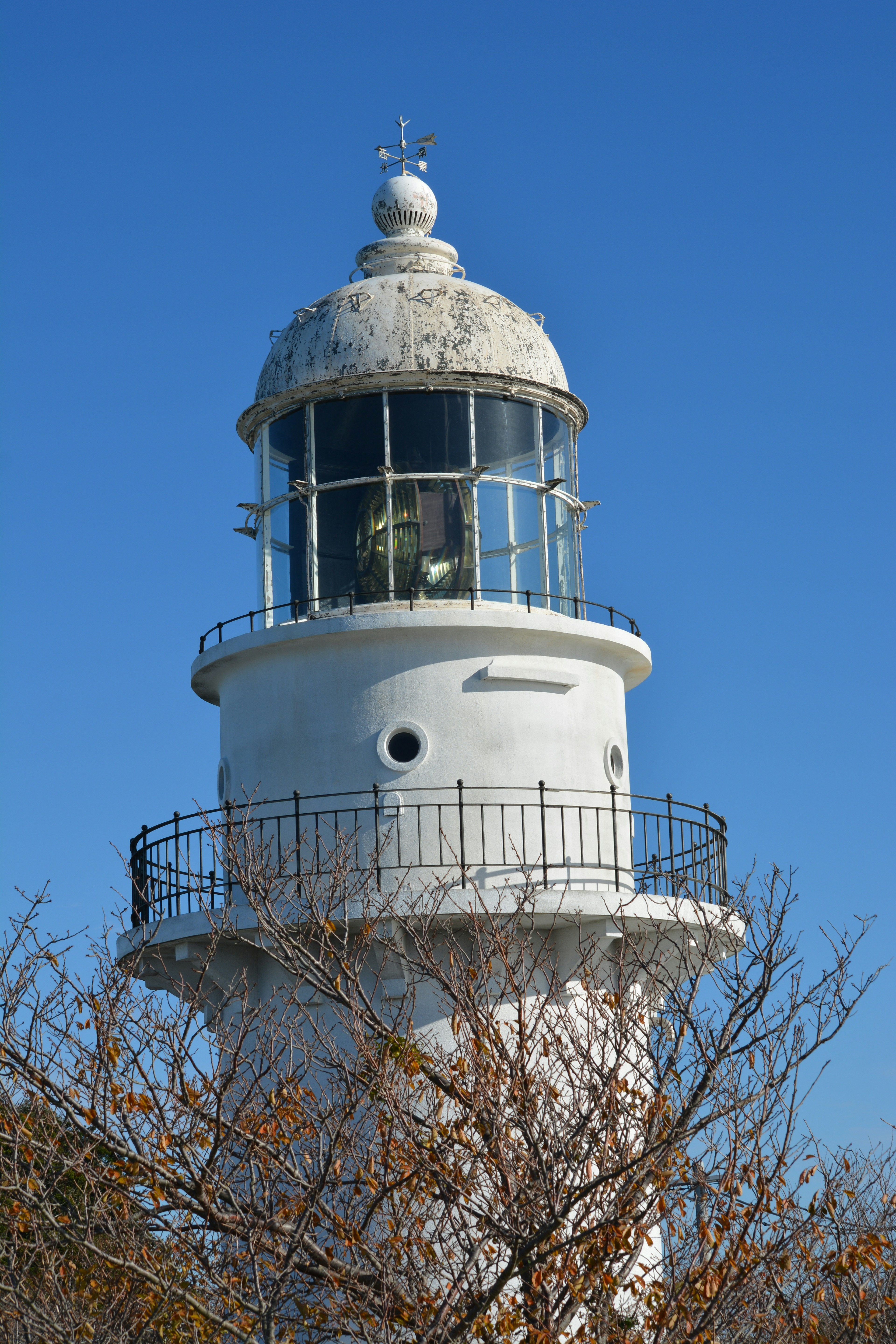 Sommet d'un phare blanc sous un ciel bleu clair