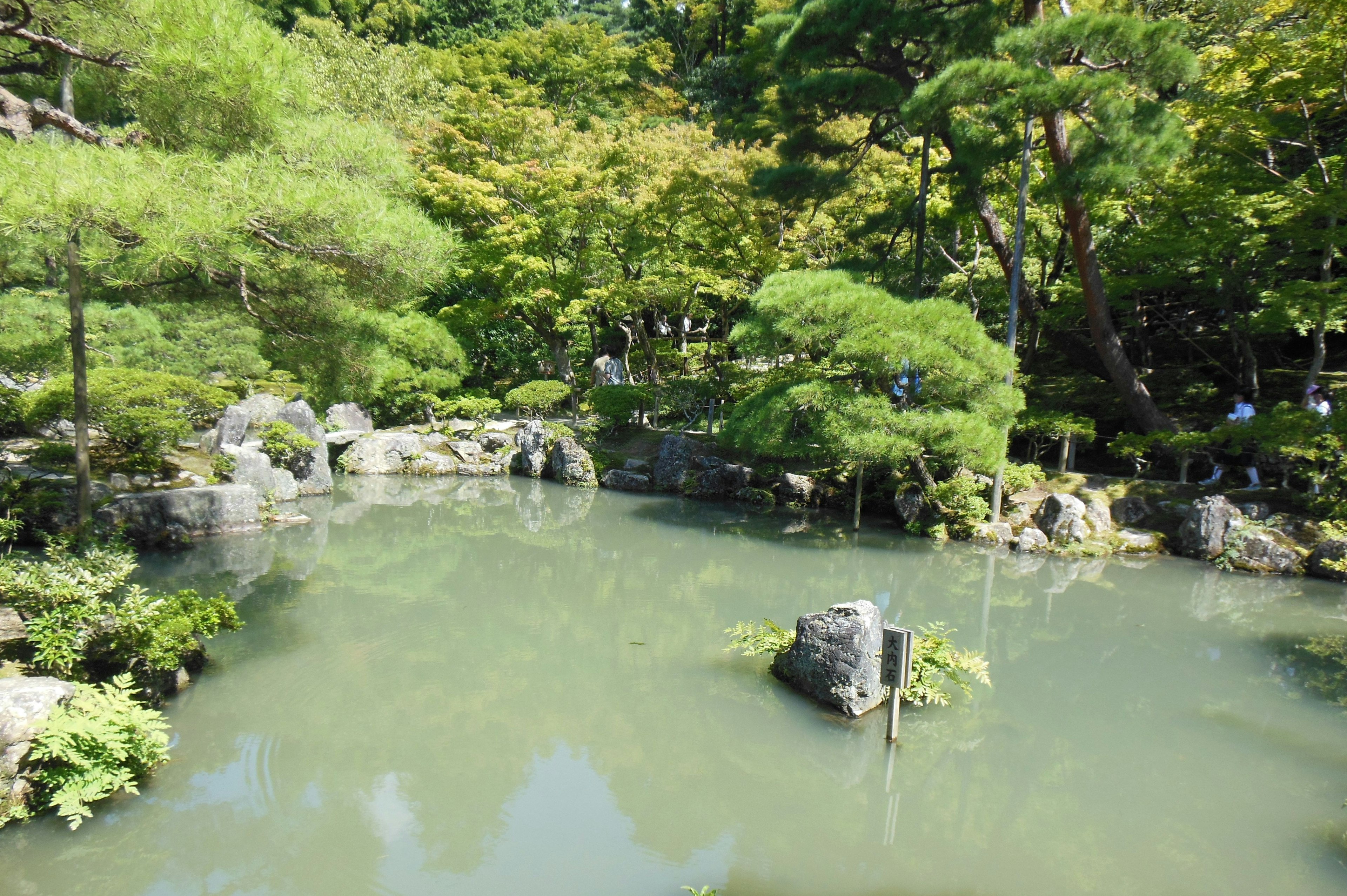 Ruhiger Teich umgeben von üppigem Grün in einem japanischen Garten