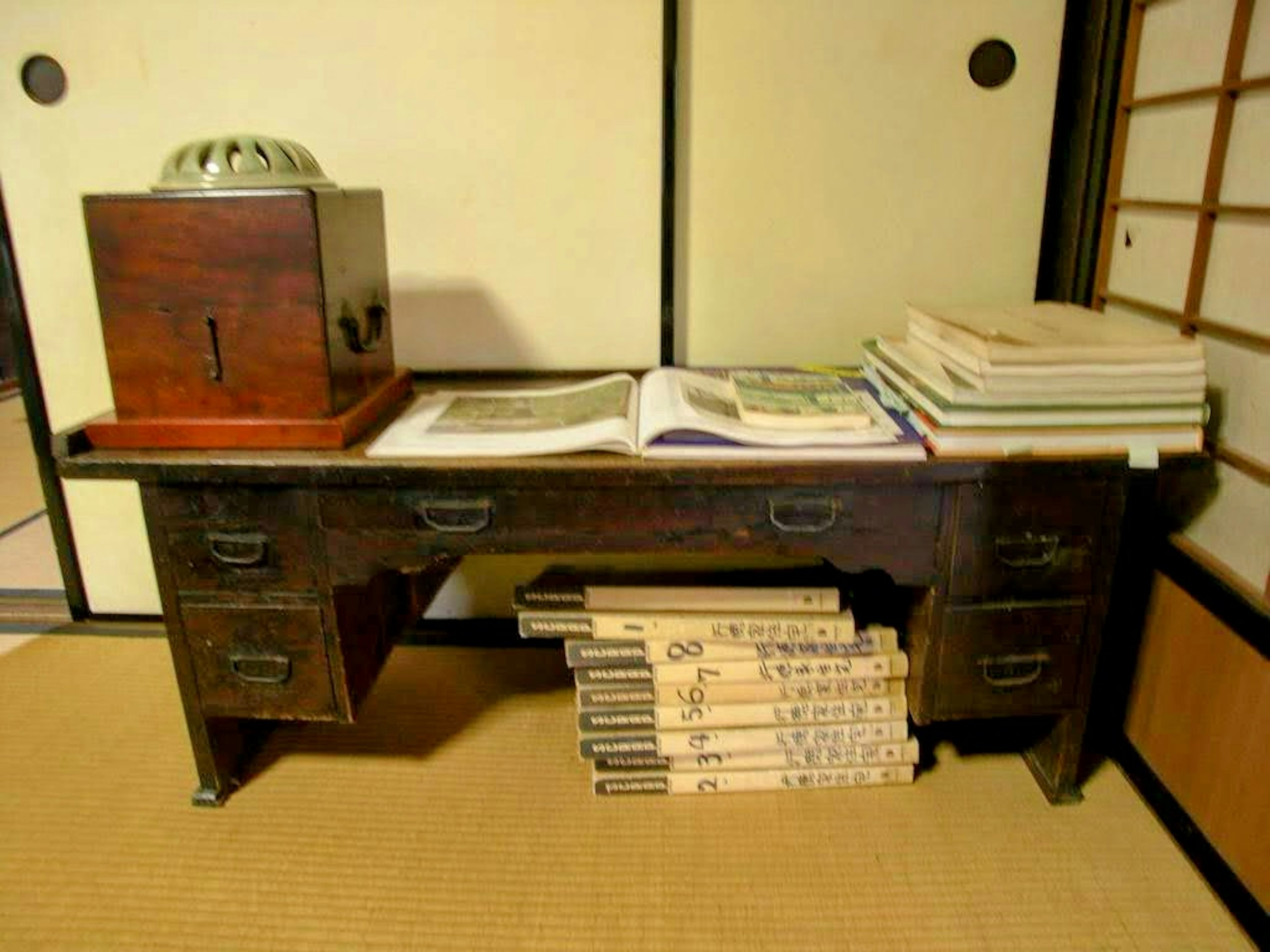 Traditional Japanese room with a wooden desk and a wooden box on top of books