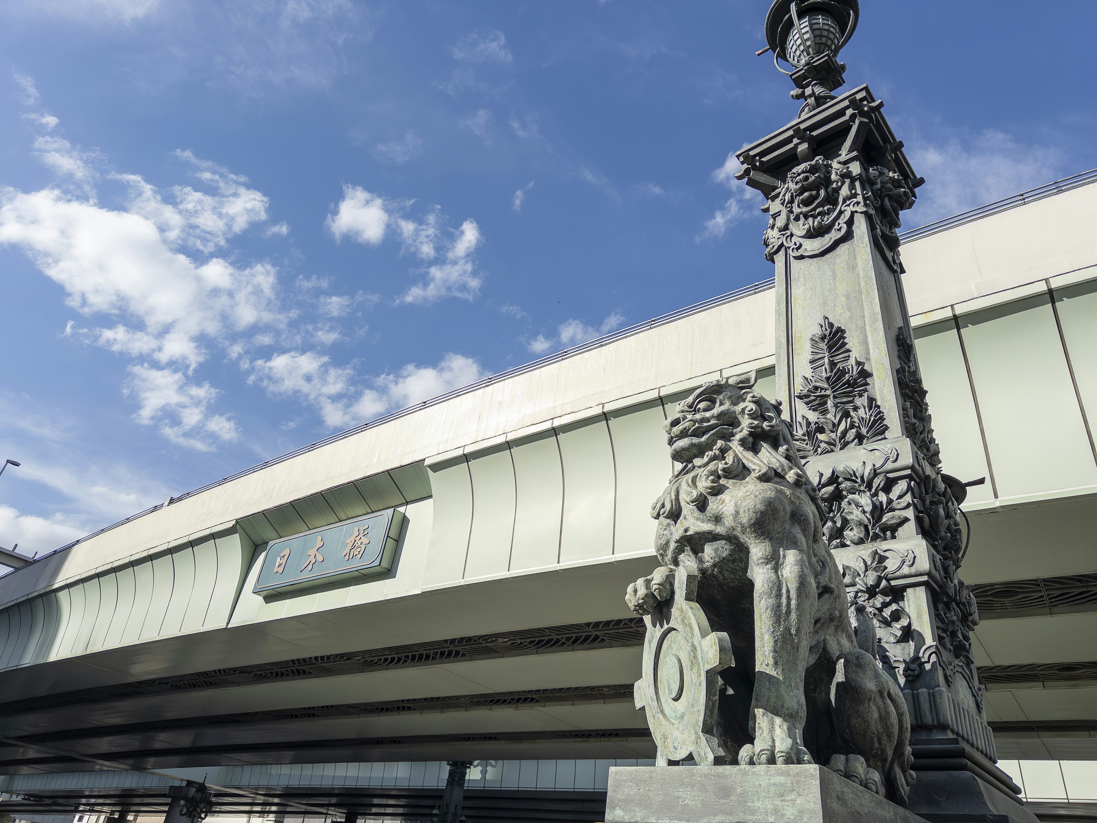 Decorative stone column with sculptures under a blue sky