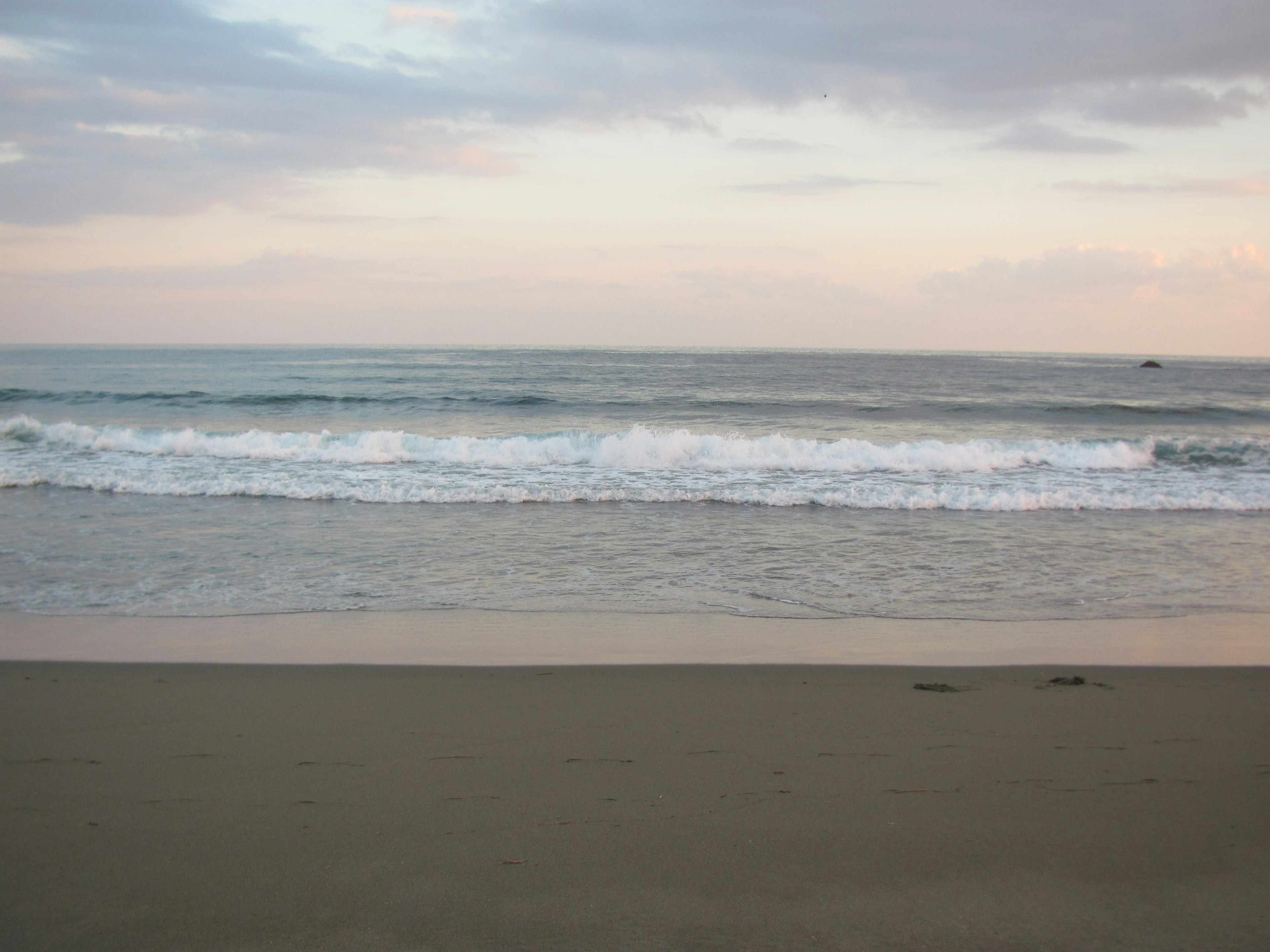 ทิวทัศน์ทะเลสงบและชายหาดทรายท้องฟ้านุ่มนวลและคลื่นอ่อน