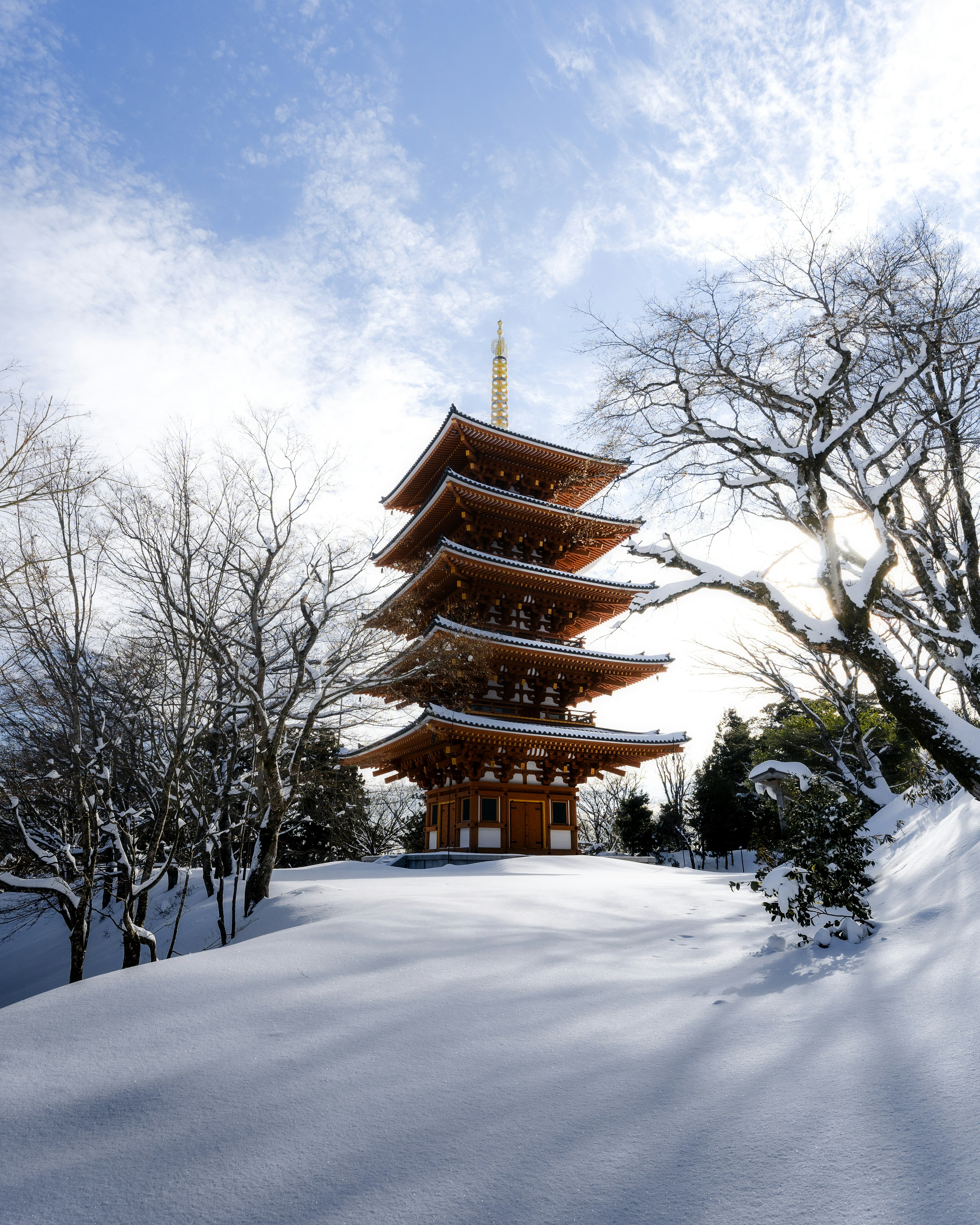 Five-story pagoda covered in snow with a blue sky