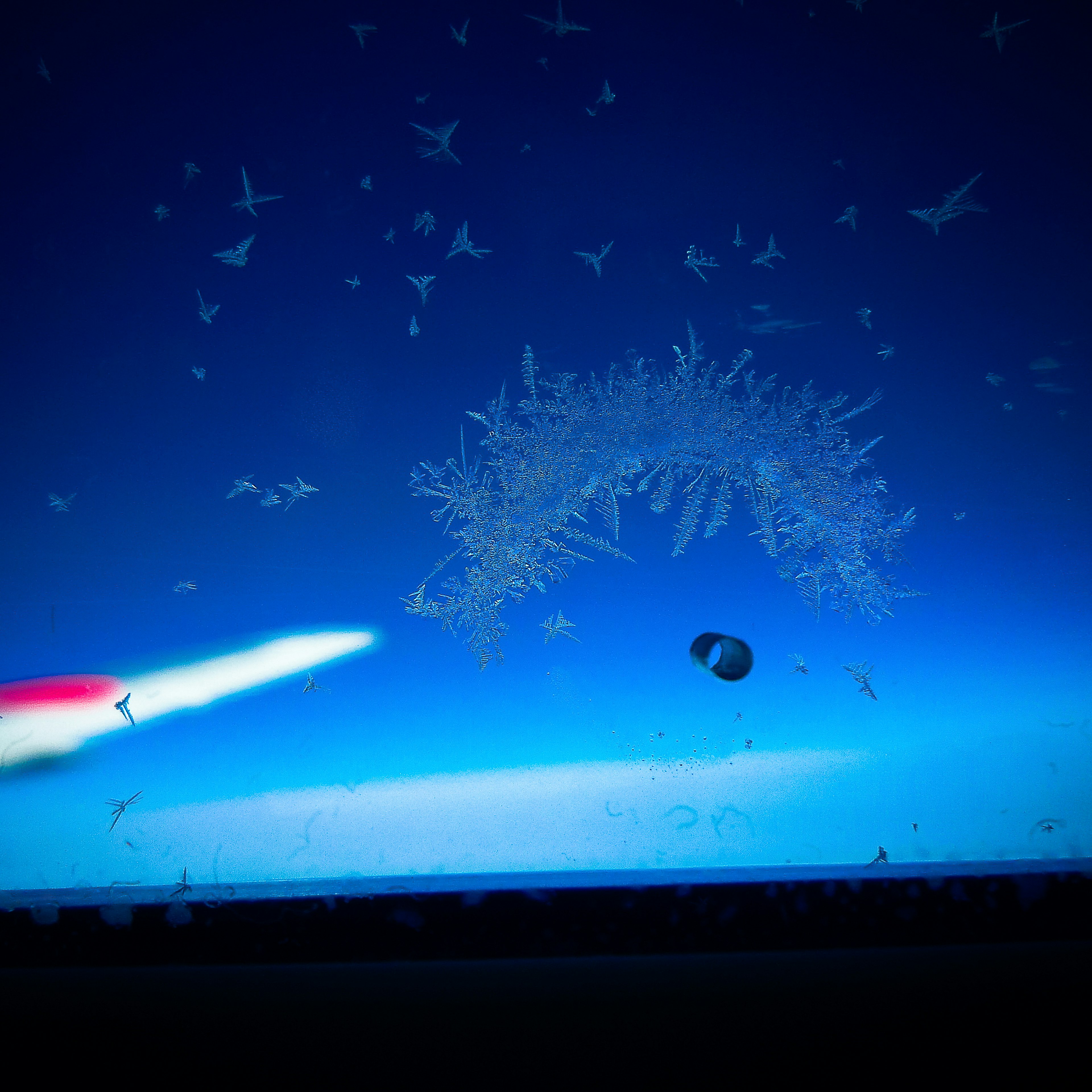 A view through a window showcasing snowflake-like patterns against a blue sky