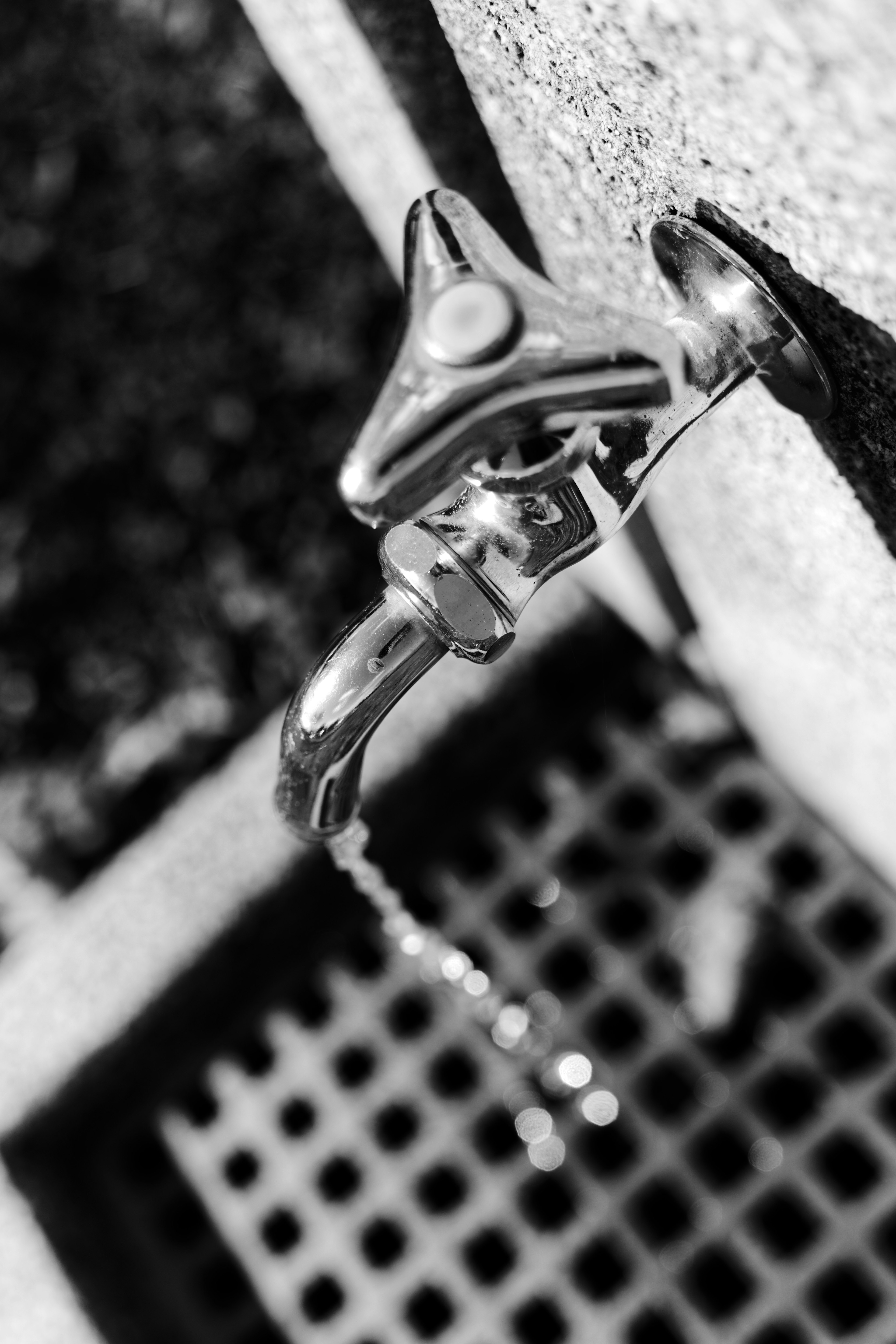 Black and white image of a faucet with water dripping from it