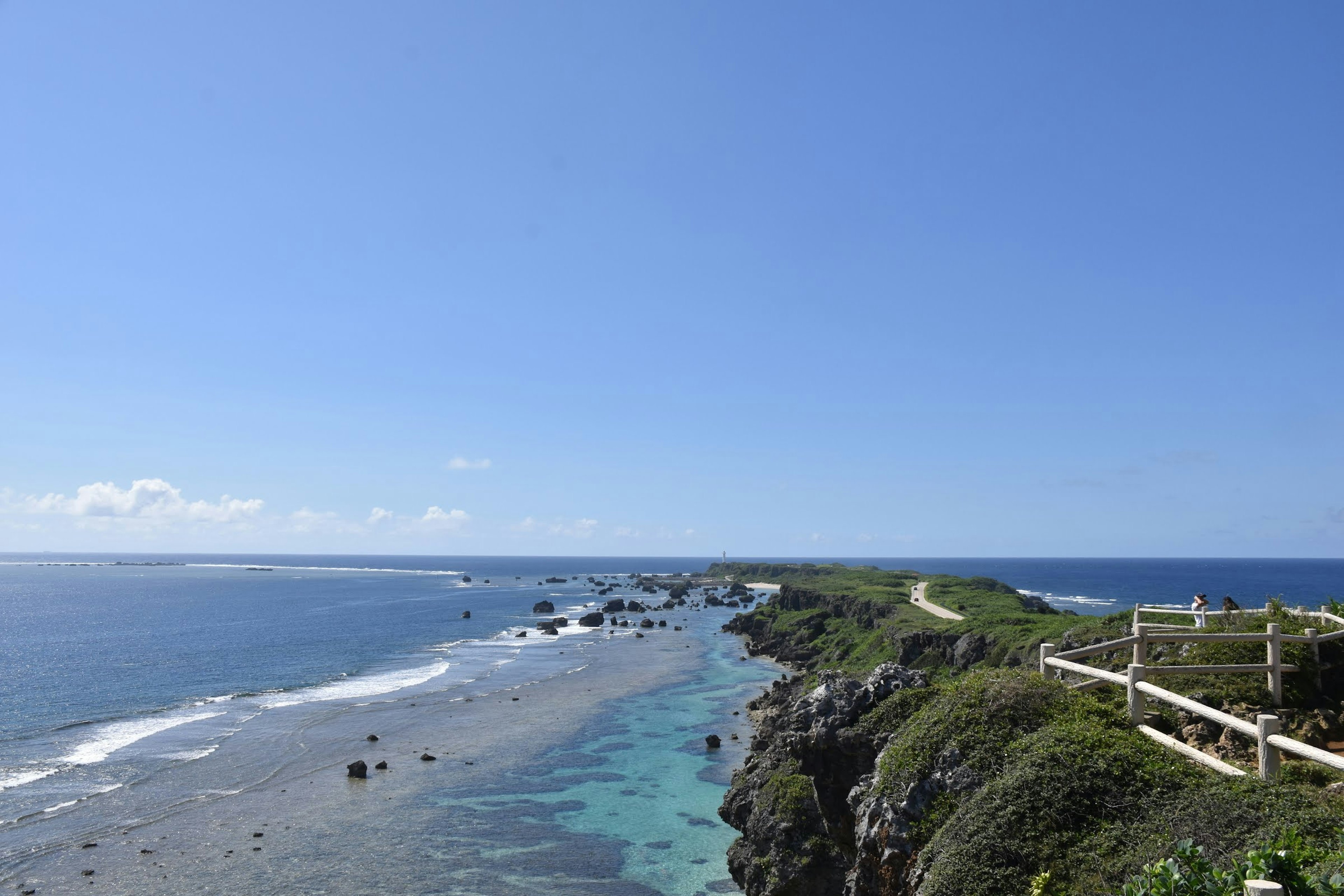 Pemandangan indah pantai dengan laut biru dan langit pasir dan tebing terlihat