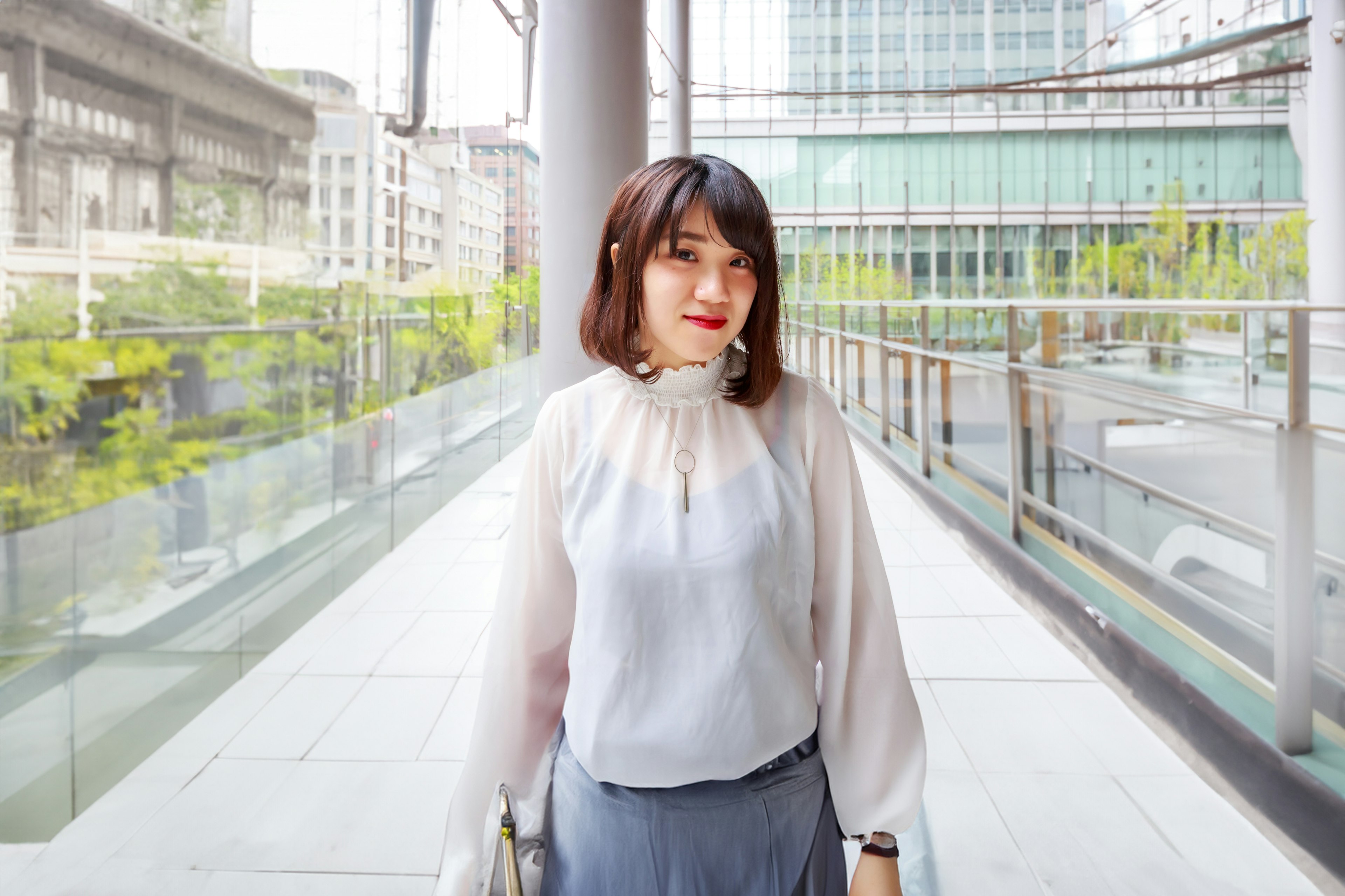 Woman in a white blouse standing in an urban setting