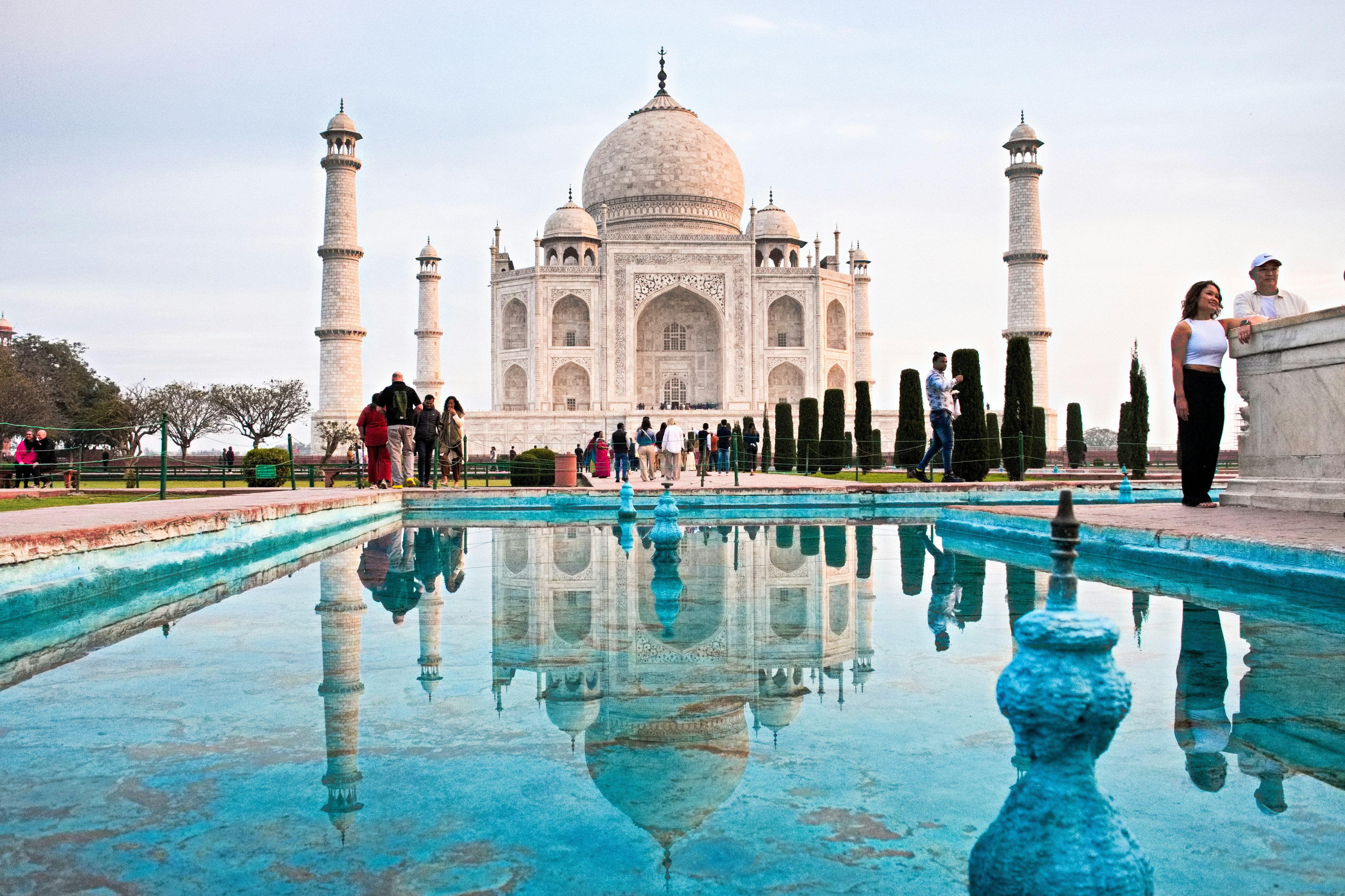 Taj Mahal với phản chiếu đẹp trong nước và du khách gần đó