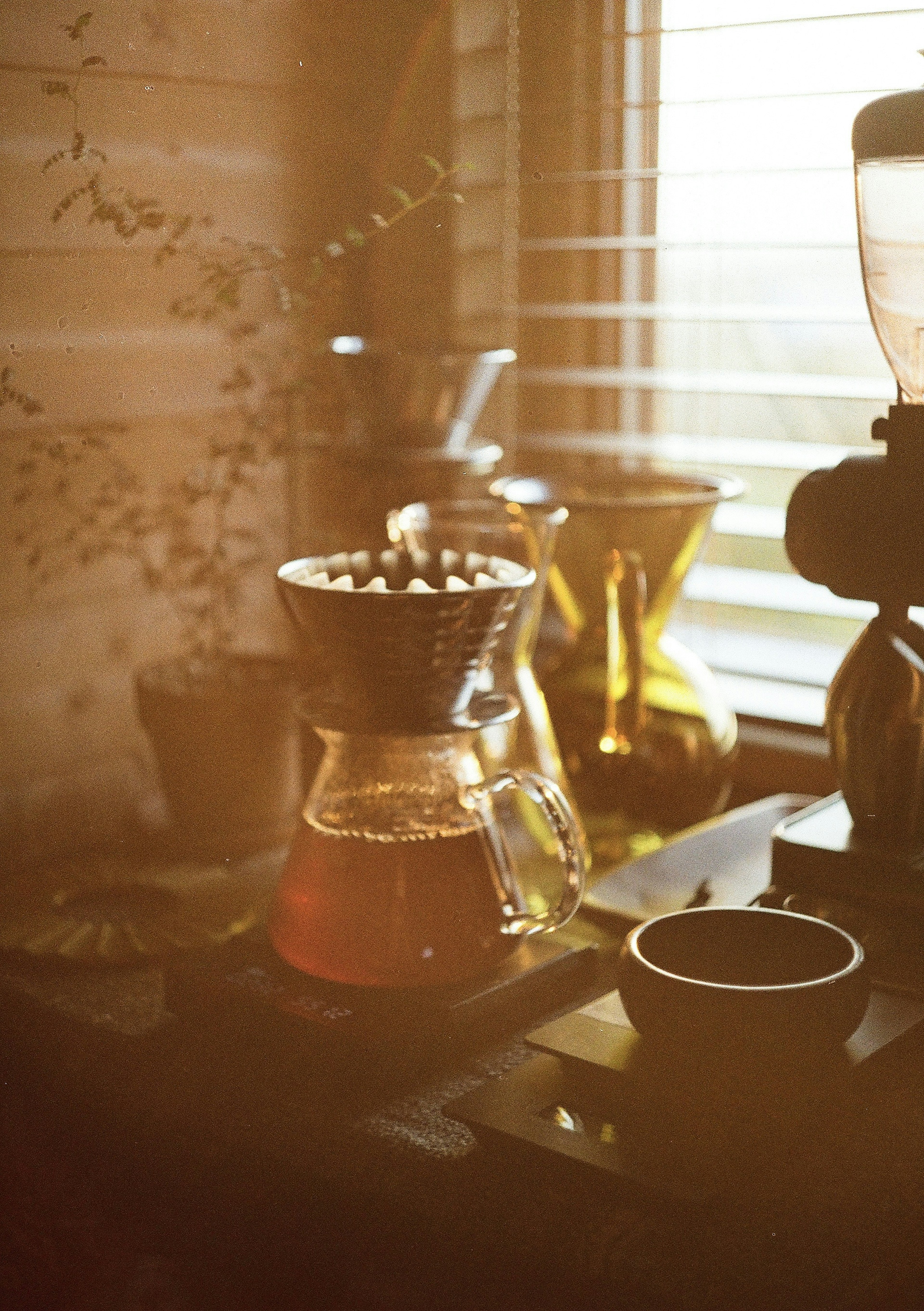 Eine ruhige Kaffeestation am Fenster mit Brühgeräten und einer Tasse