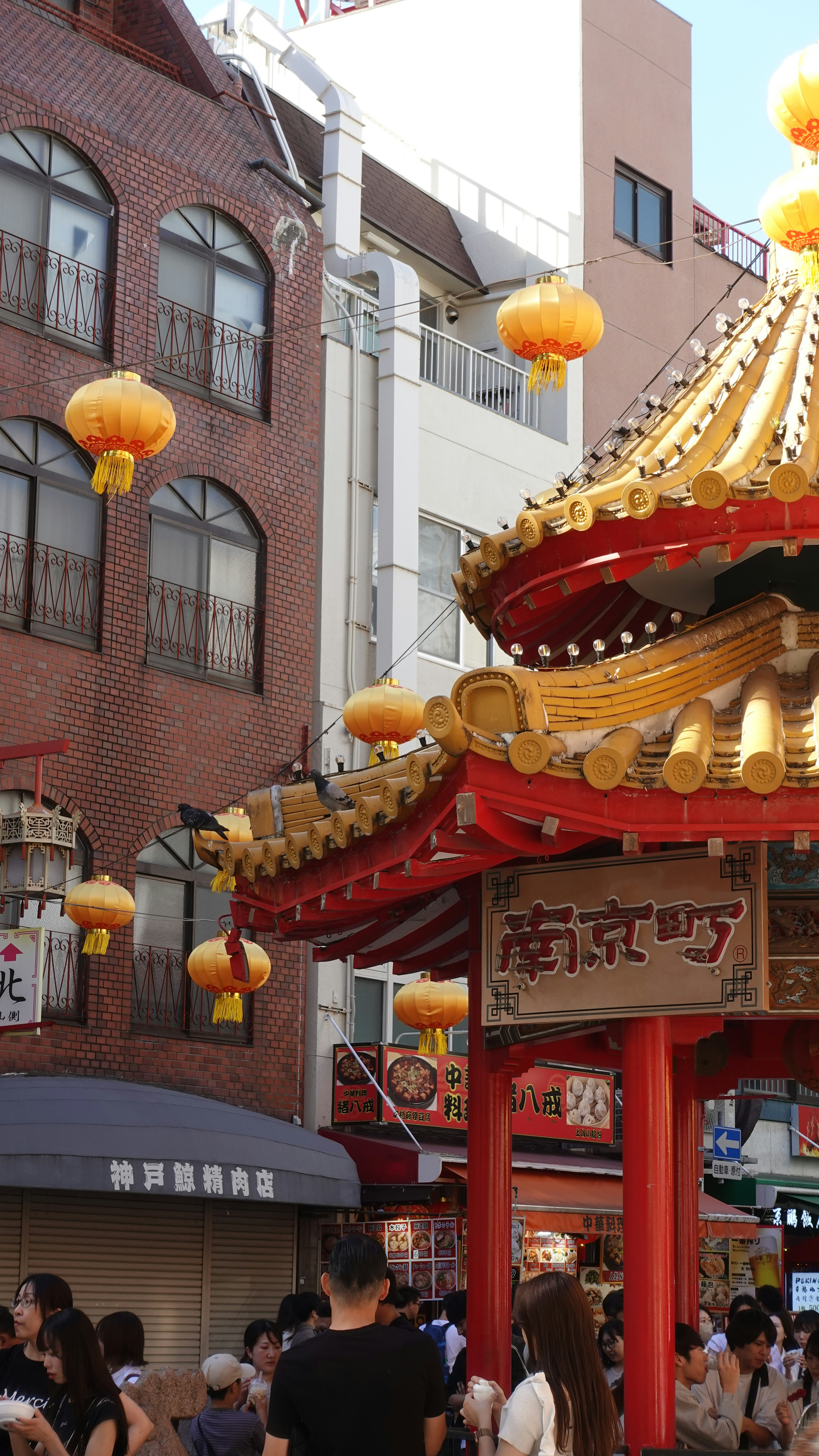 Calle bulliciosa en Chinatown con una puerta roja y faroles amarillos