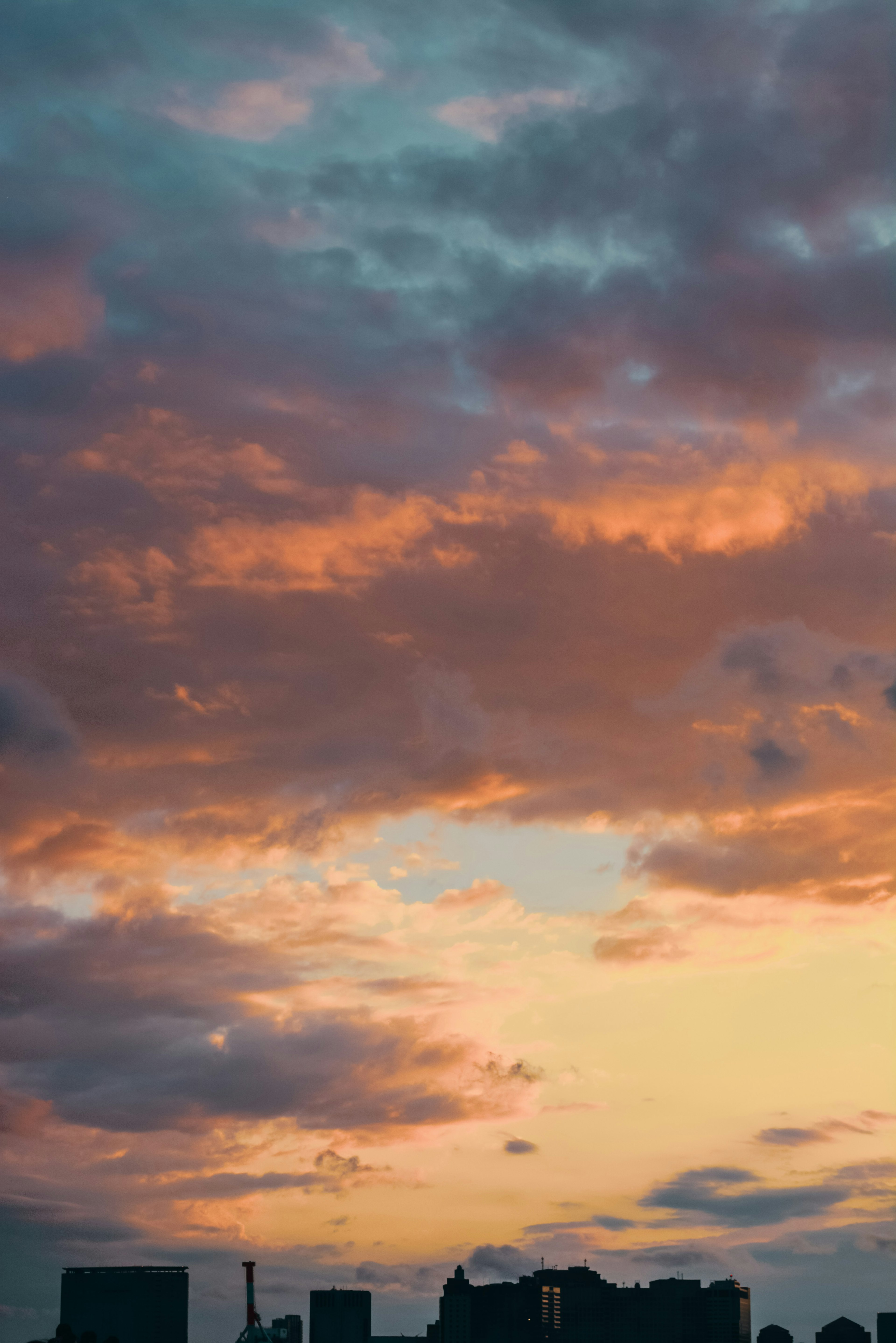 美しい夕焼けの空に浮かぶ雲とシルエットのビル