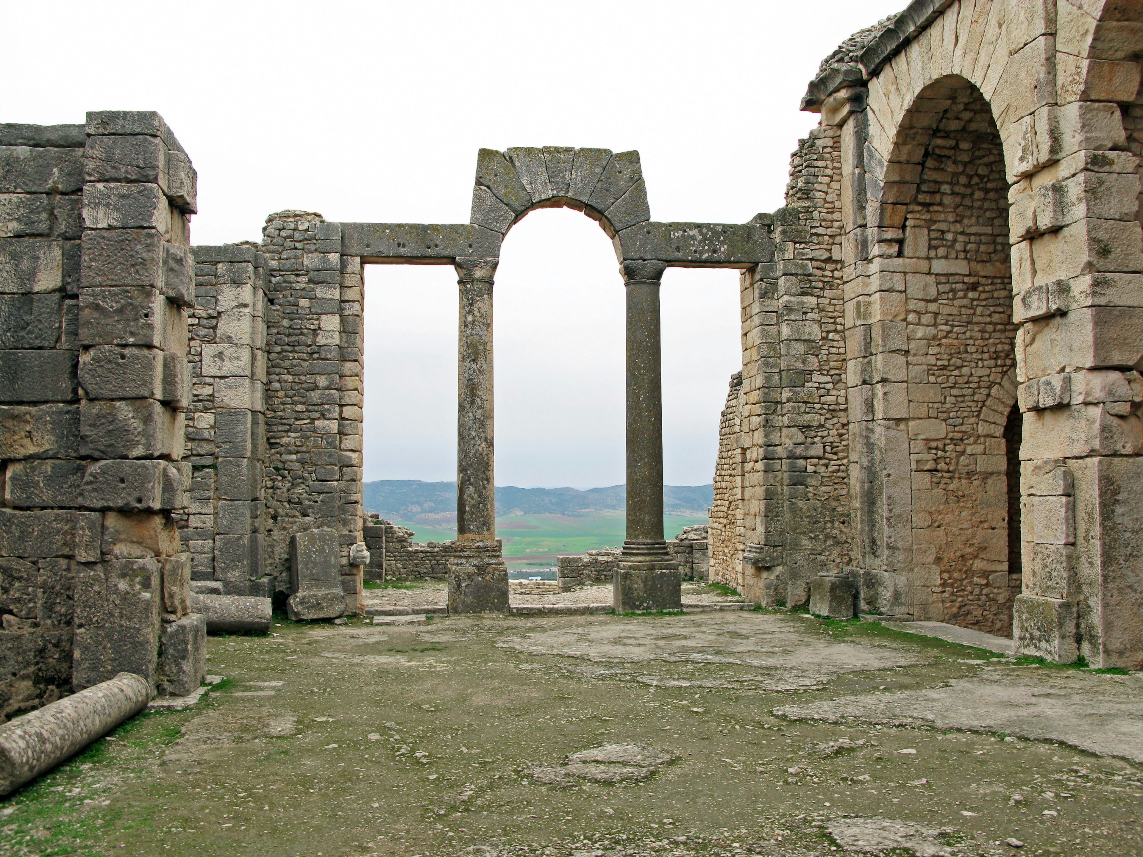 Vue des ruines anciennes avec une arche et des structures en pierre