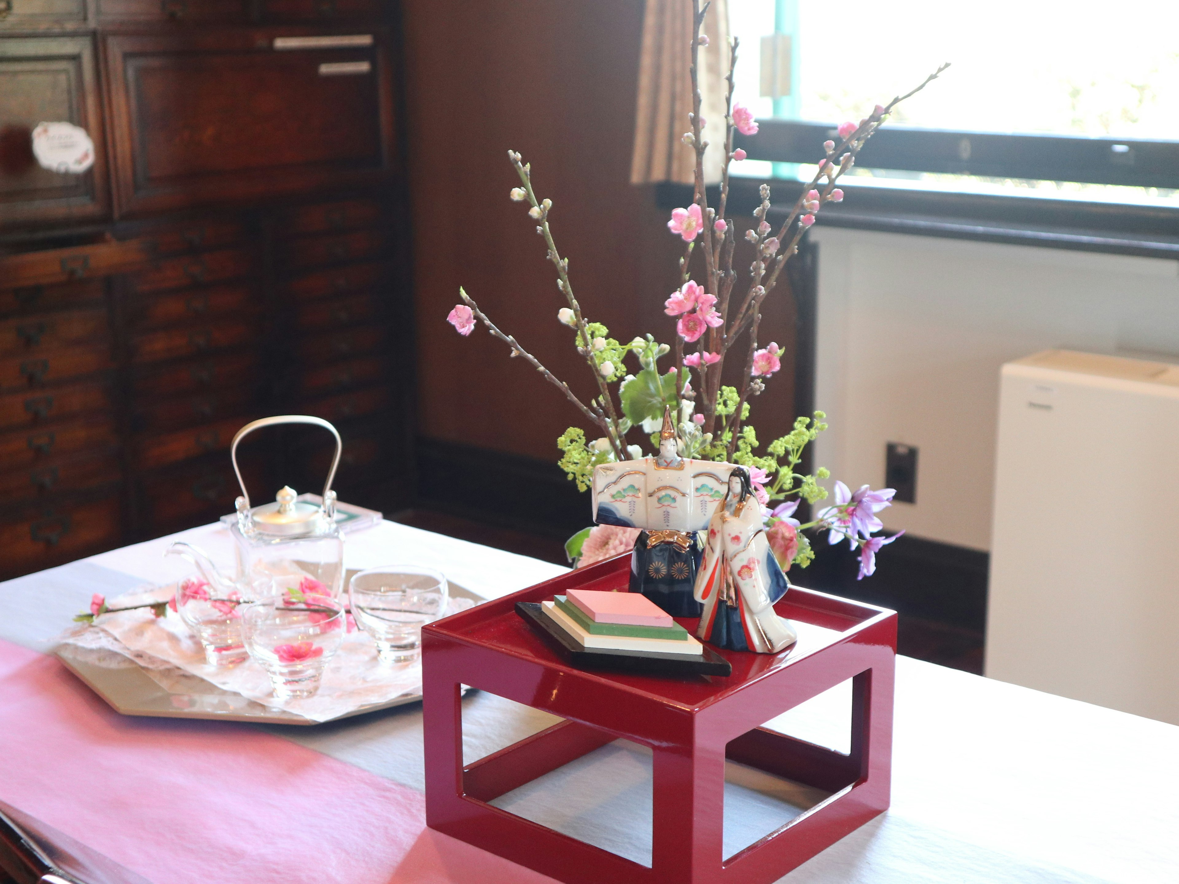 Tisch geschmückt mit einer Vase mit Blumen und traditioneller Dekoration