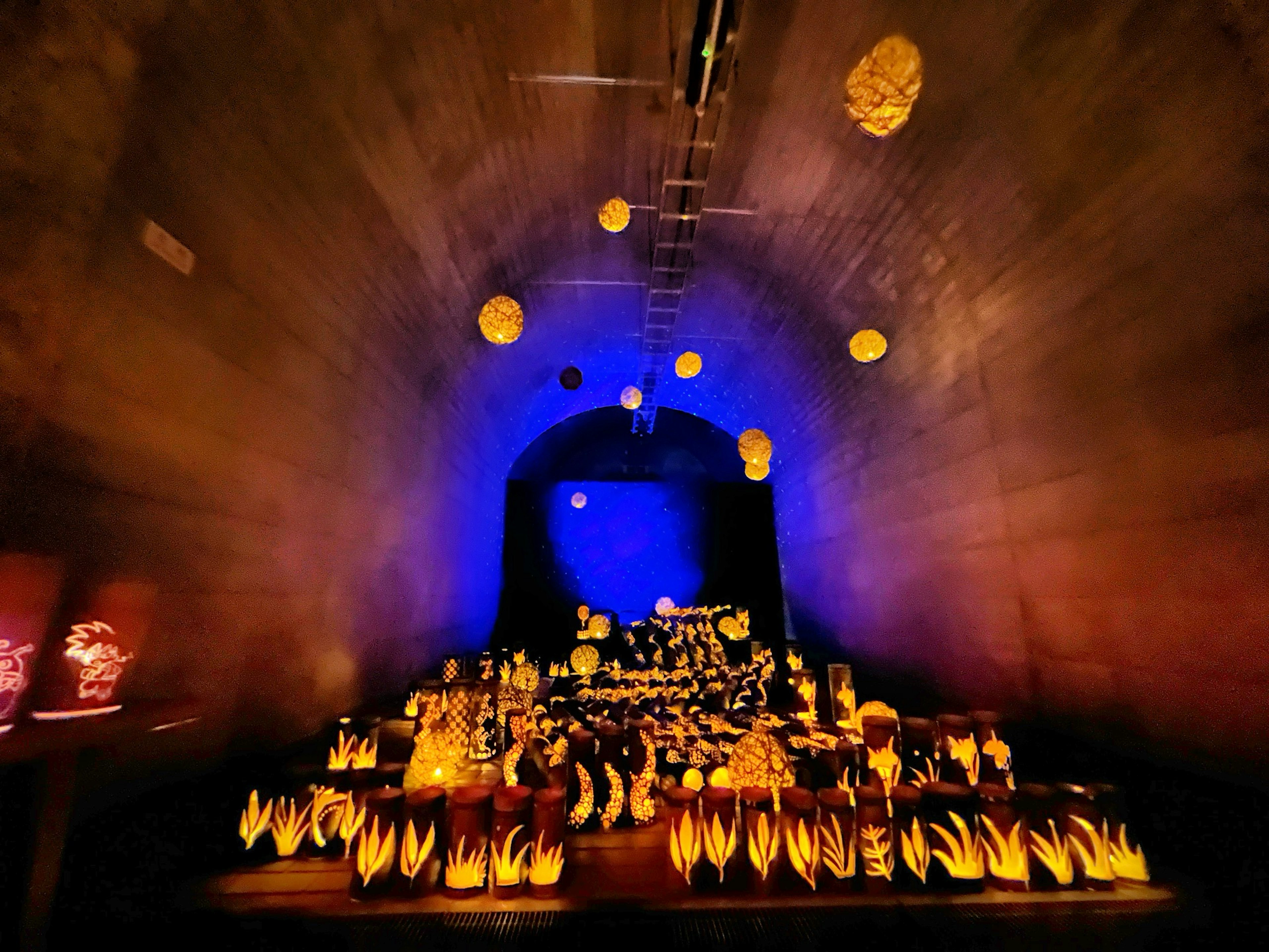 Scene of an altar illuminated with blue and yellow lights inside a cave