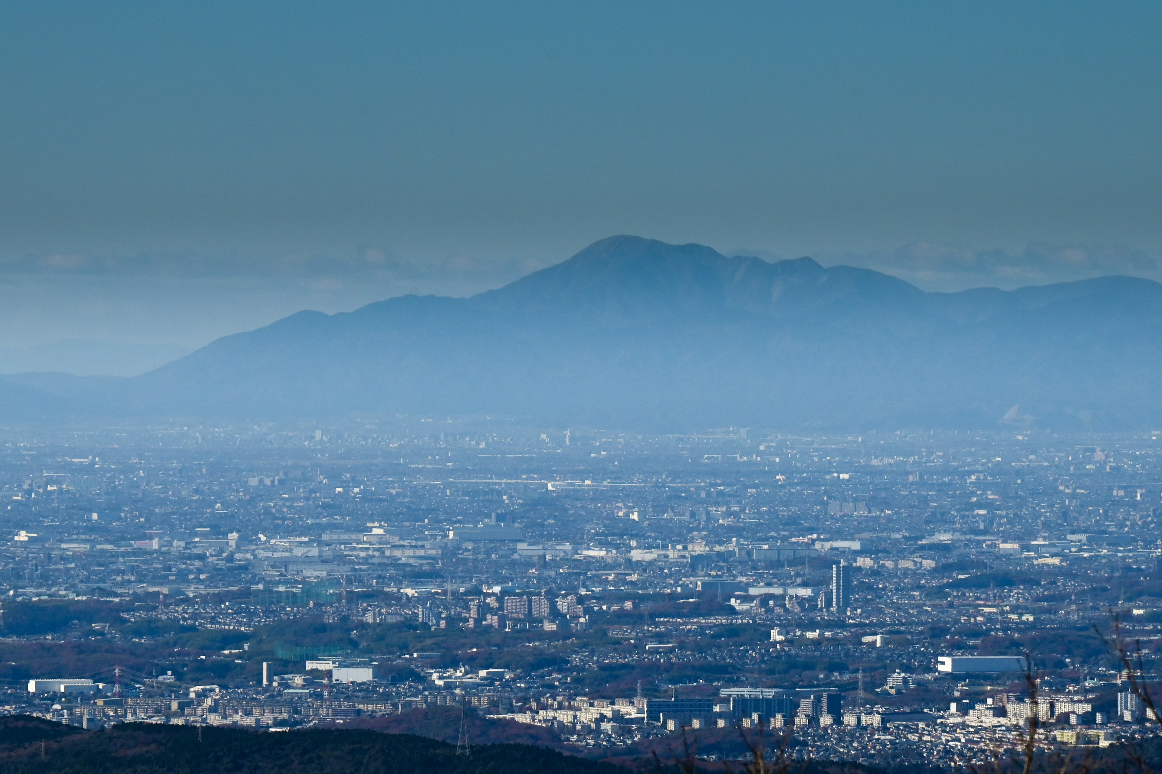 Vista distante di una montagna blu e di un paesaggio urbano