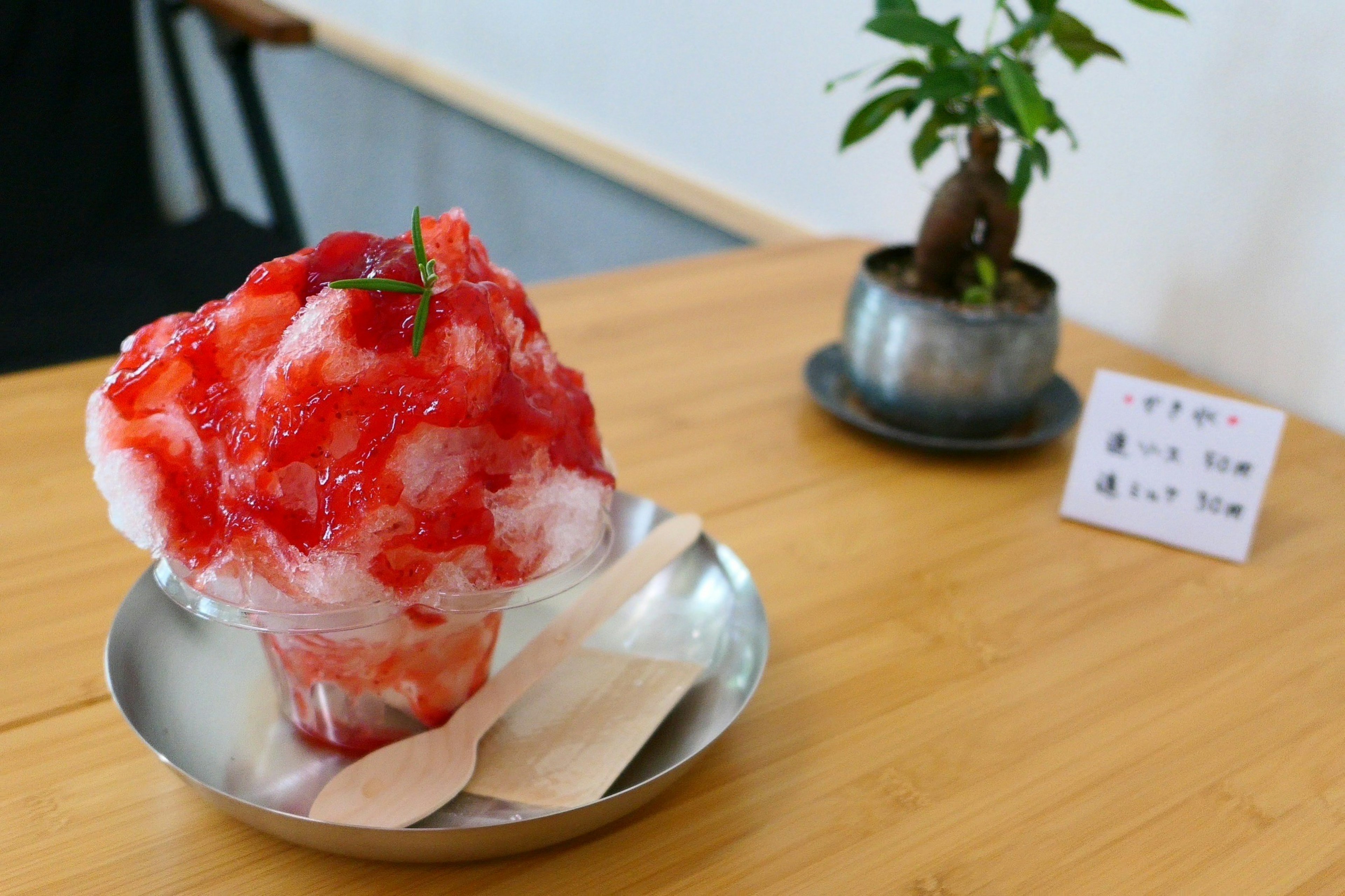 Glace pilée garnie de sirop rouge servie dans un bol en argent