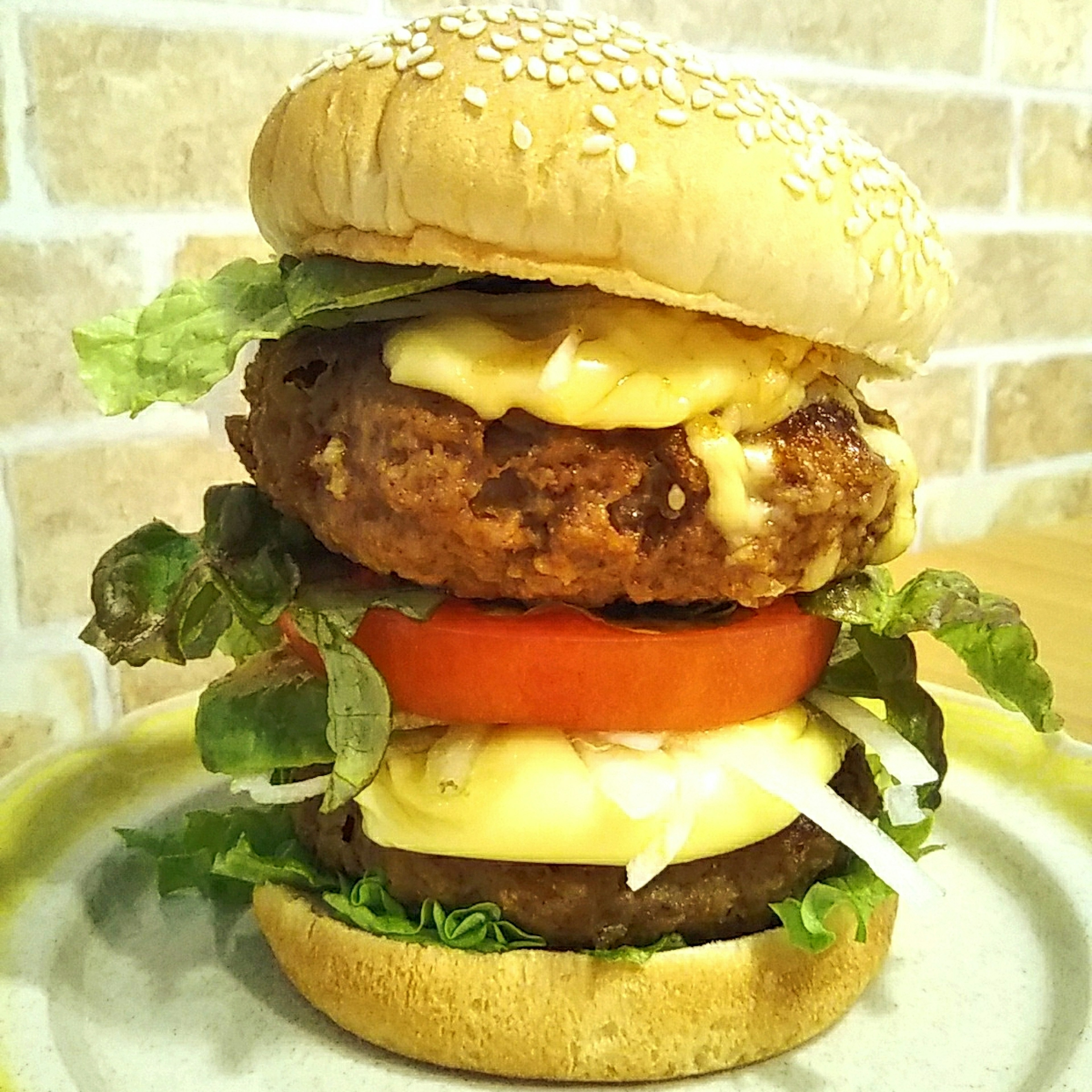 A towering burger with sesame bun lettuce mayonnaise and tomato slices