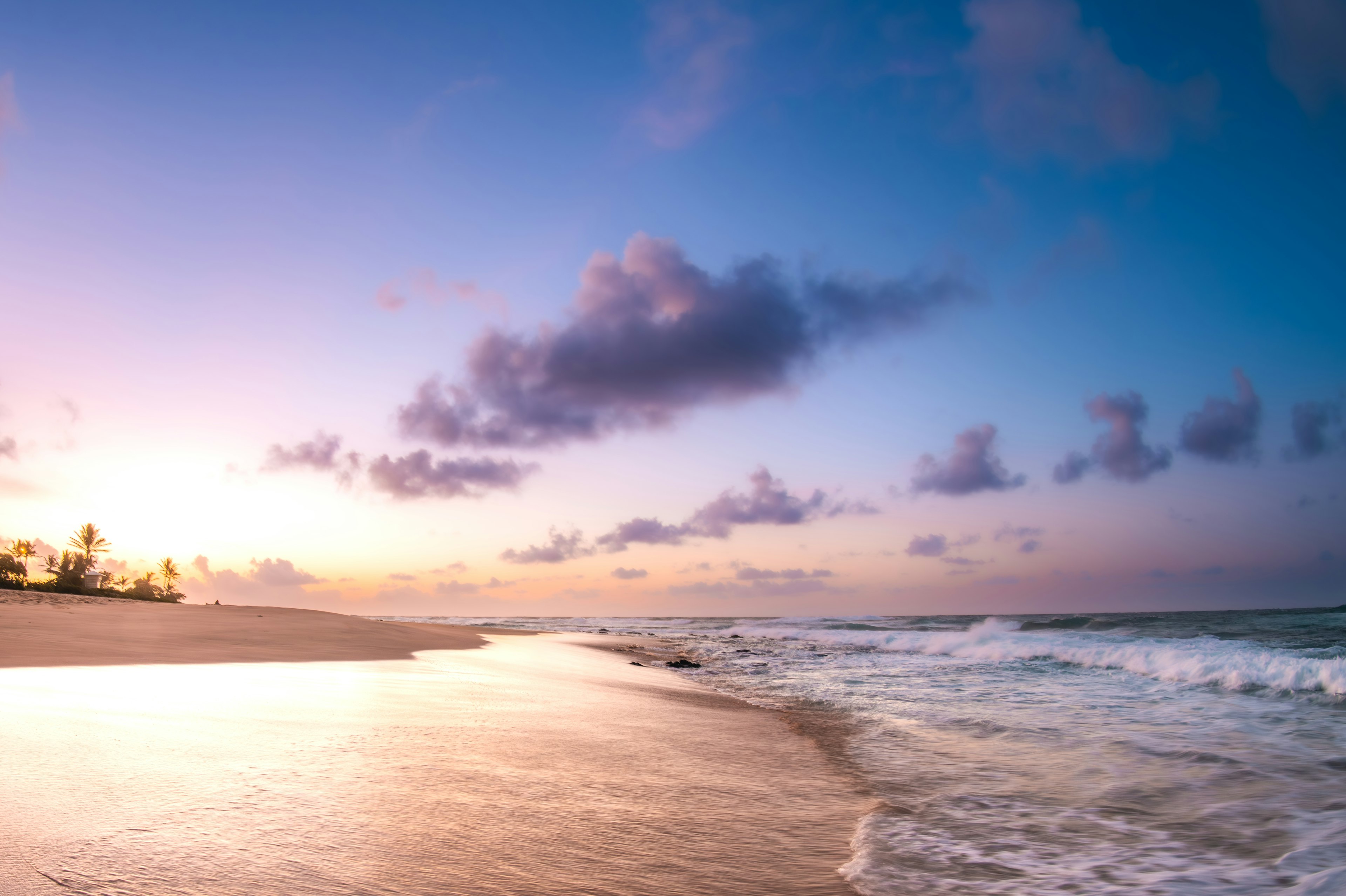 美しいビーチの夕暮れの風景、紫とオレンジの空、波が浜に打ち寄せる