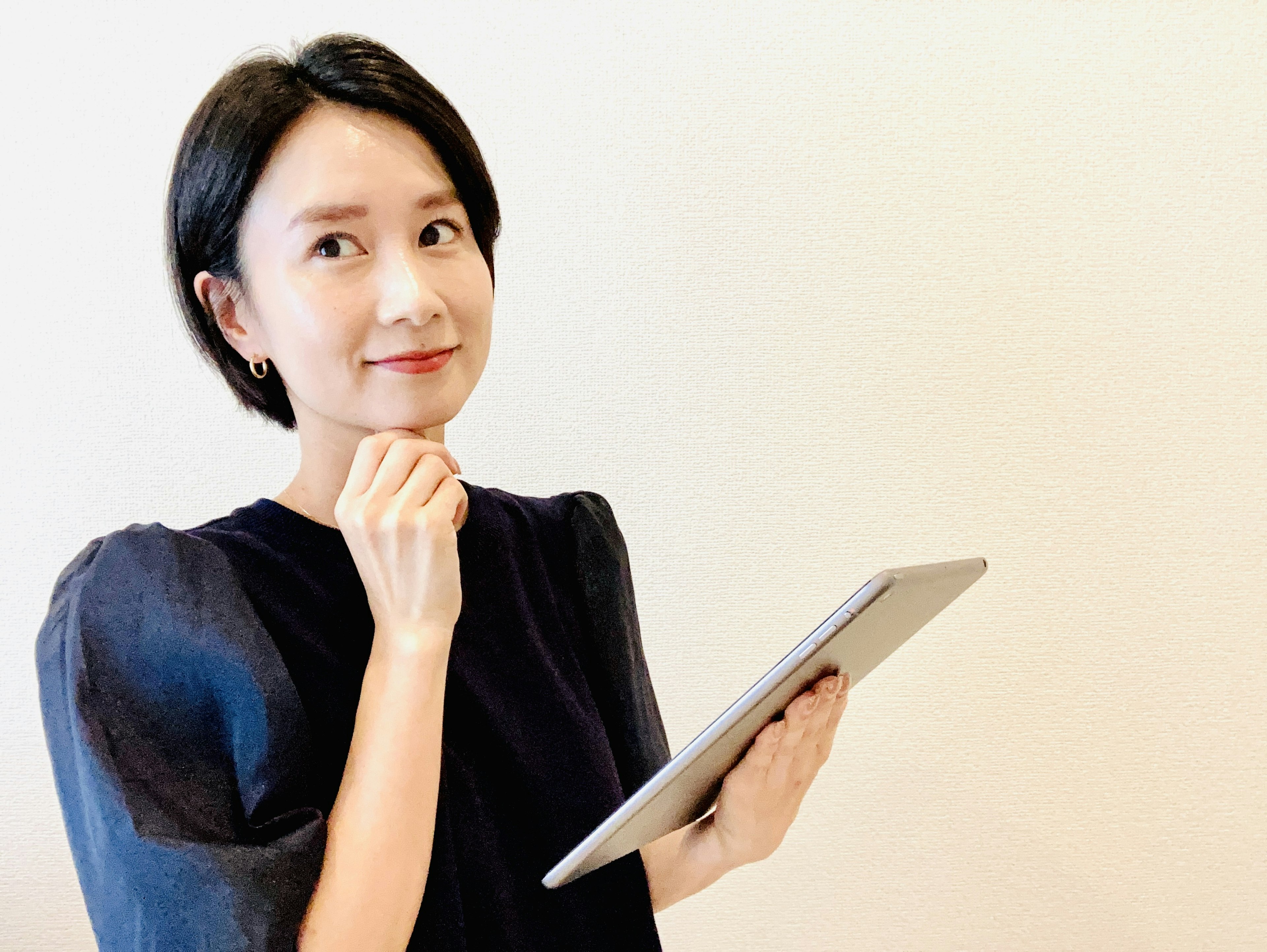 Woman holding a tablet with a thoughtful expression