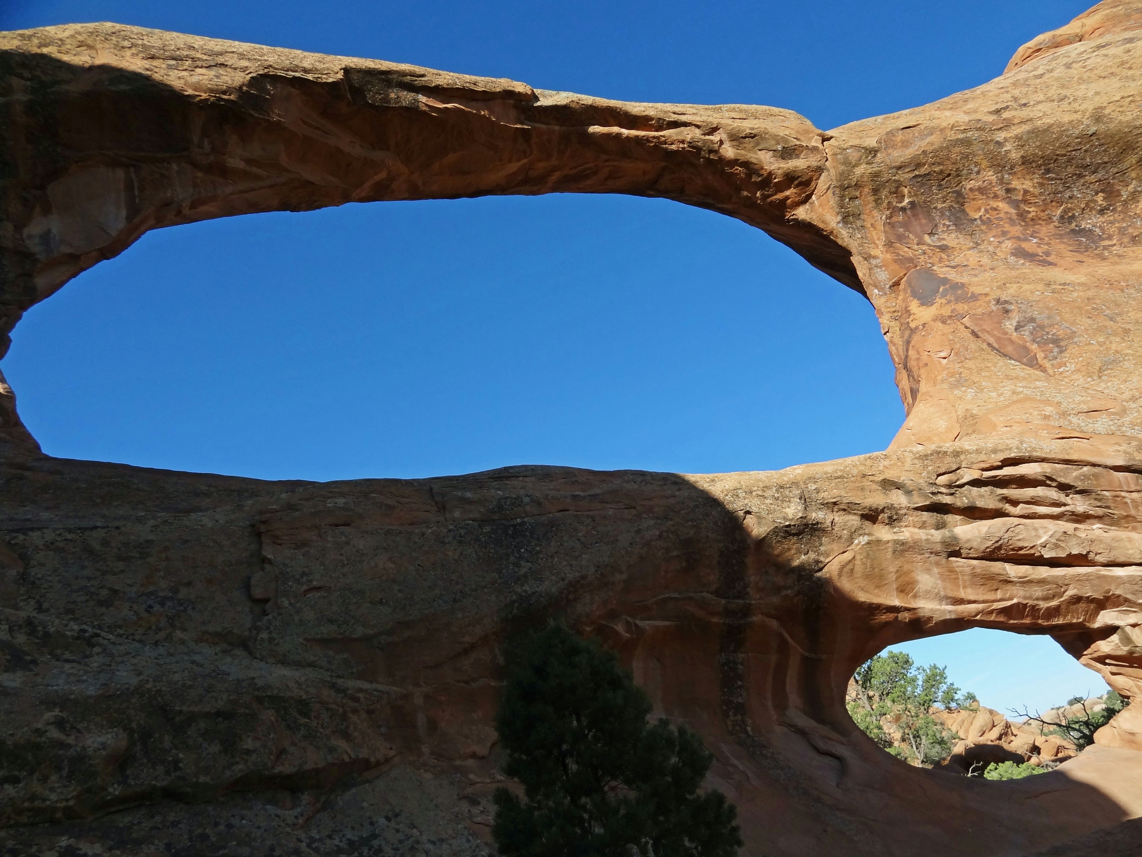 Arch-shaped rock formation against a blue sky