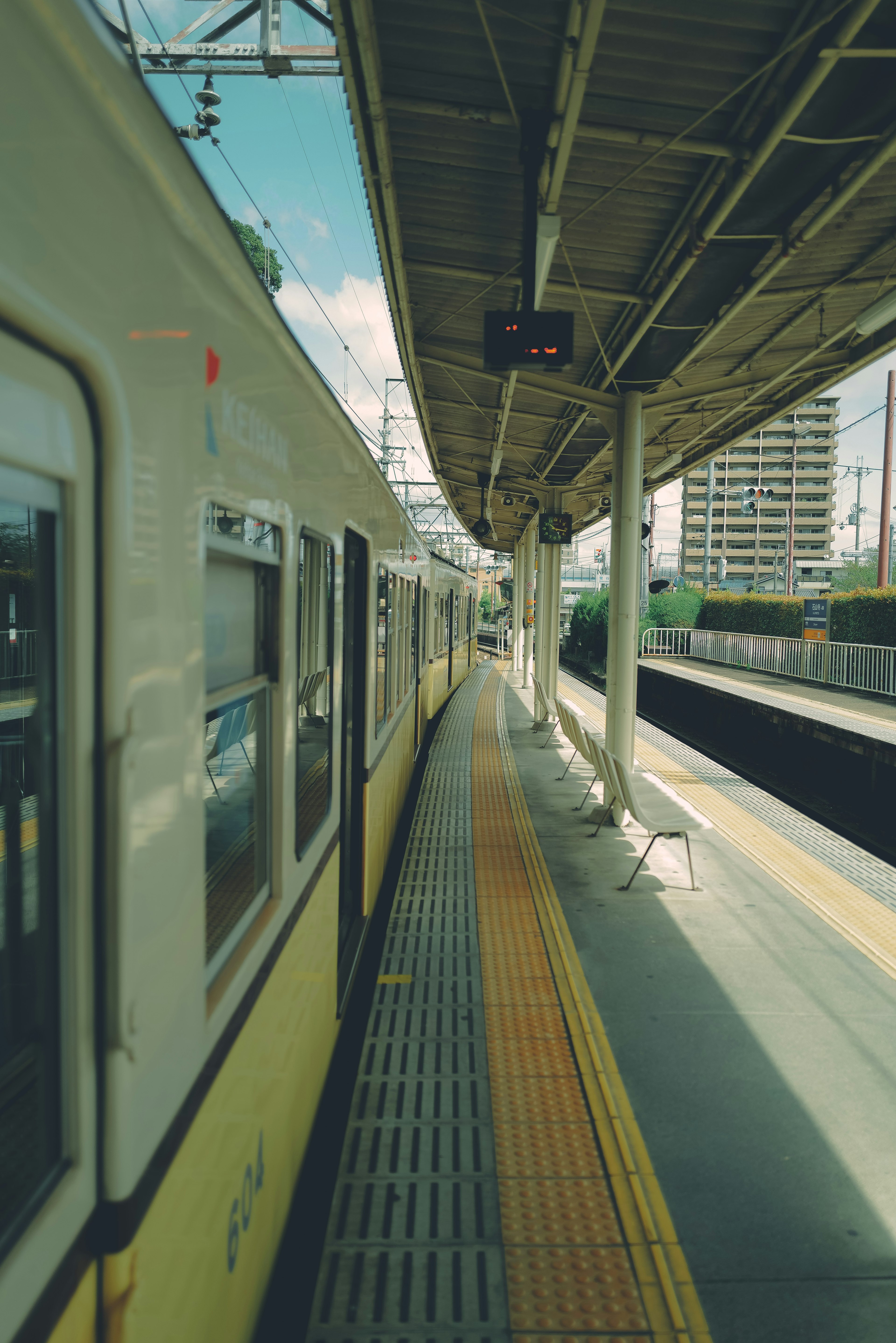 Train stopped at a platform under a blue sky