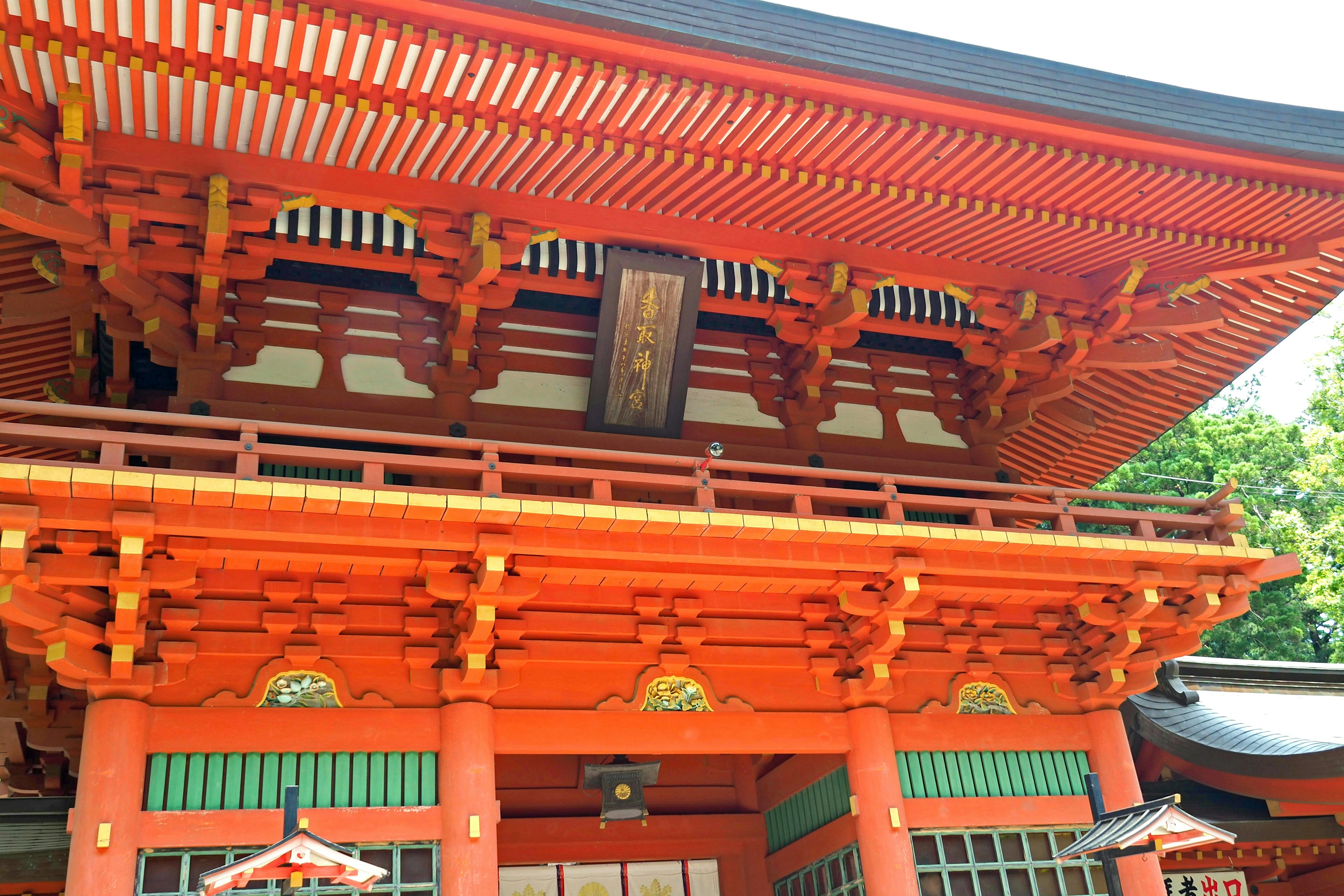 A traditional shrine building with a vibrant red roof and intricate decorations