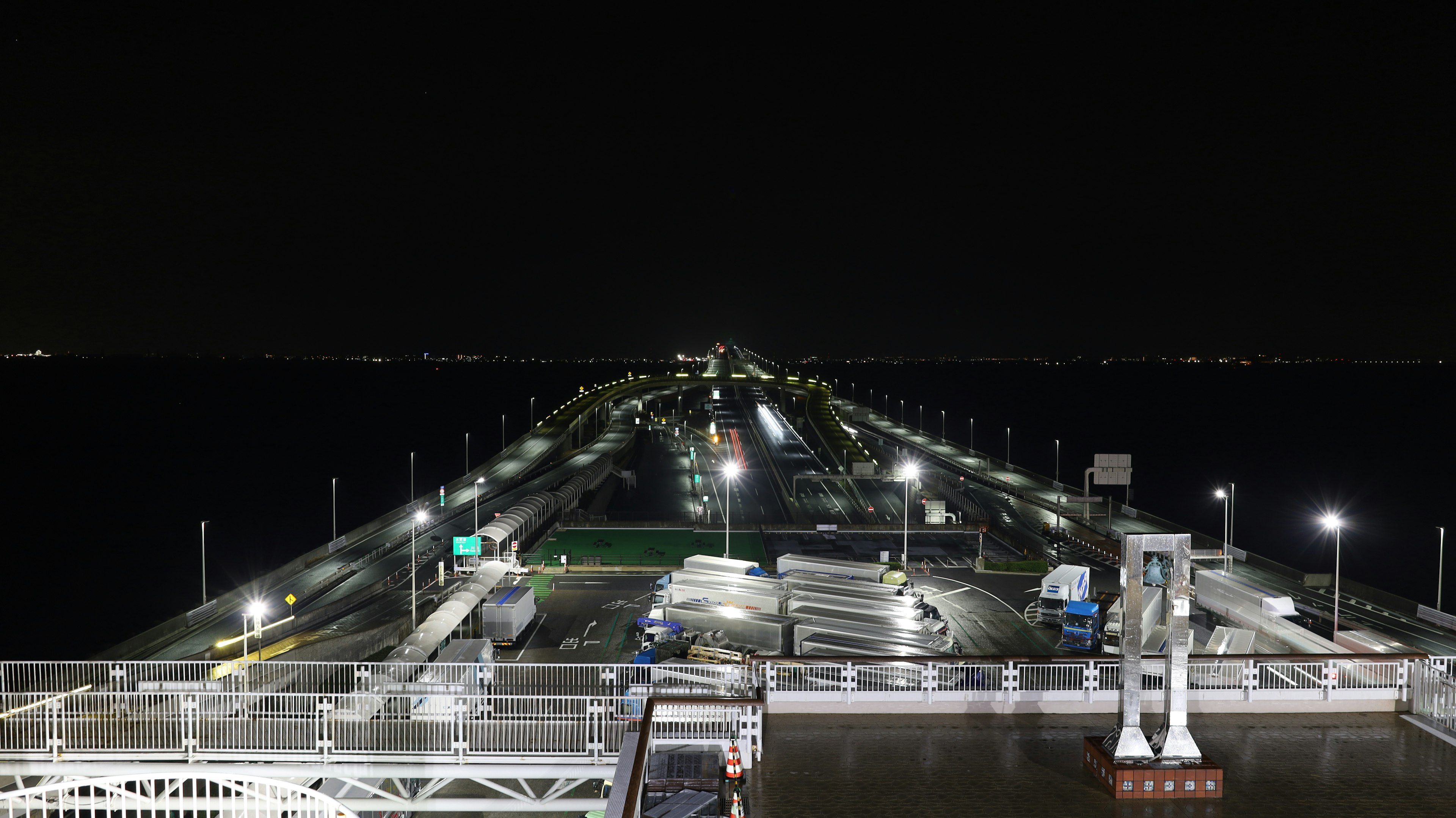 Vista notturna di un molo illuminato con un lungo pontile che si estende nell'acqua