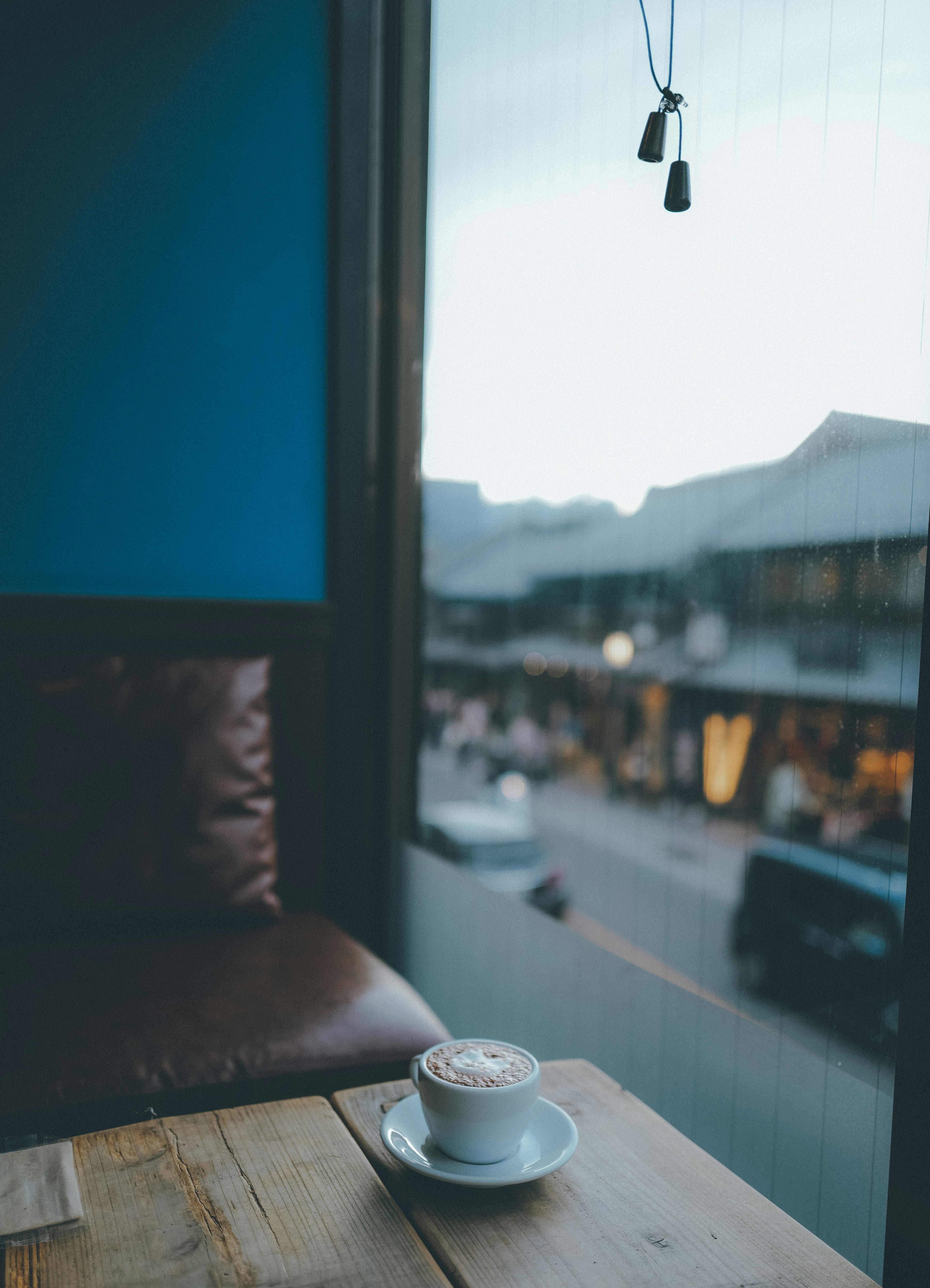 Coffee cup on a cafe table by the window with a view of the street