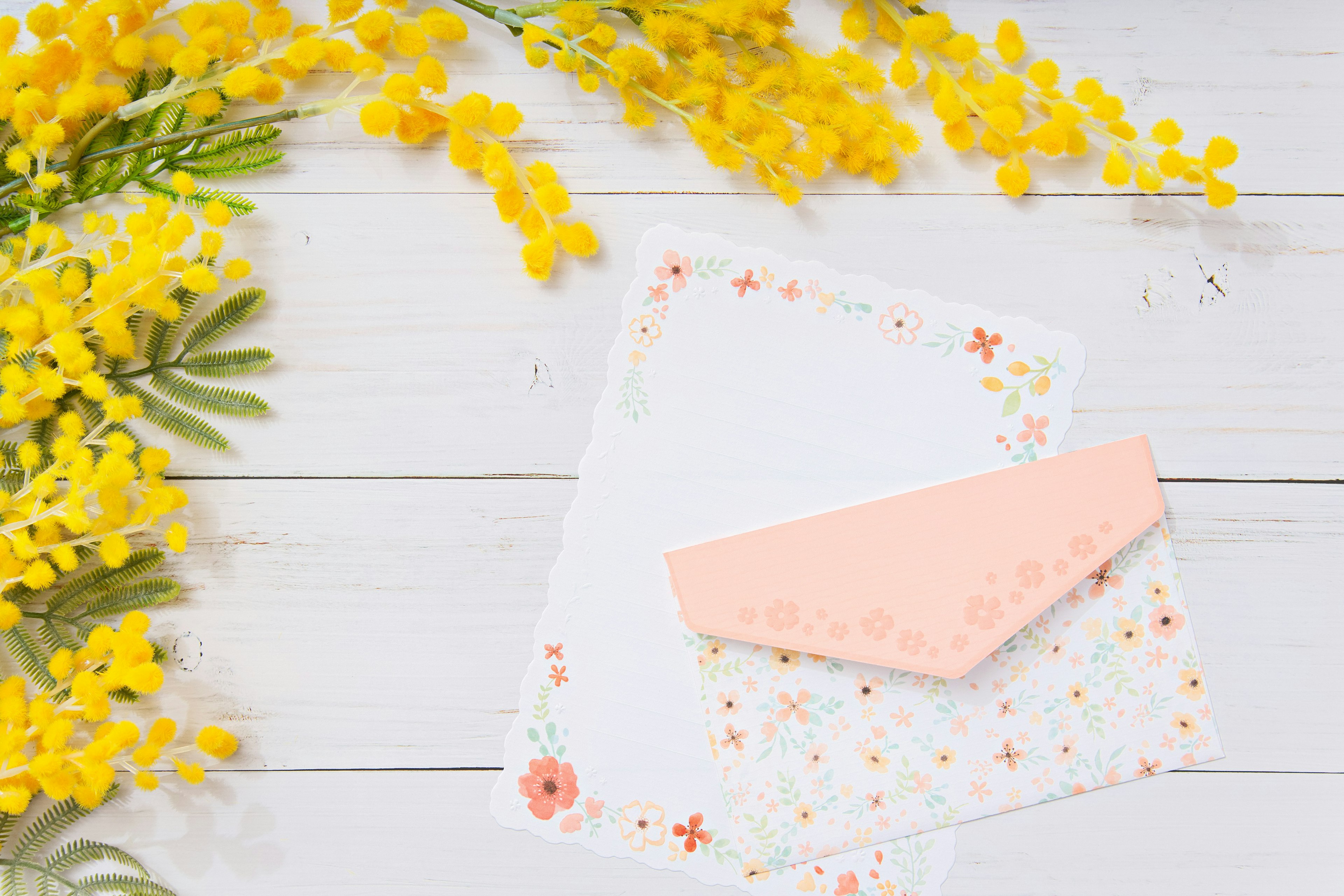 Scene featuring yellow flowers with a decorated envelope and stationery