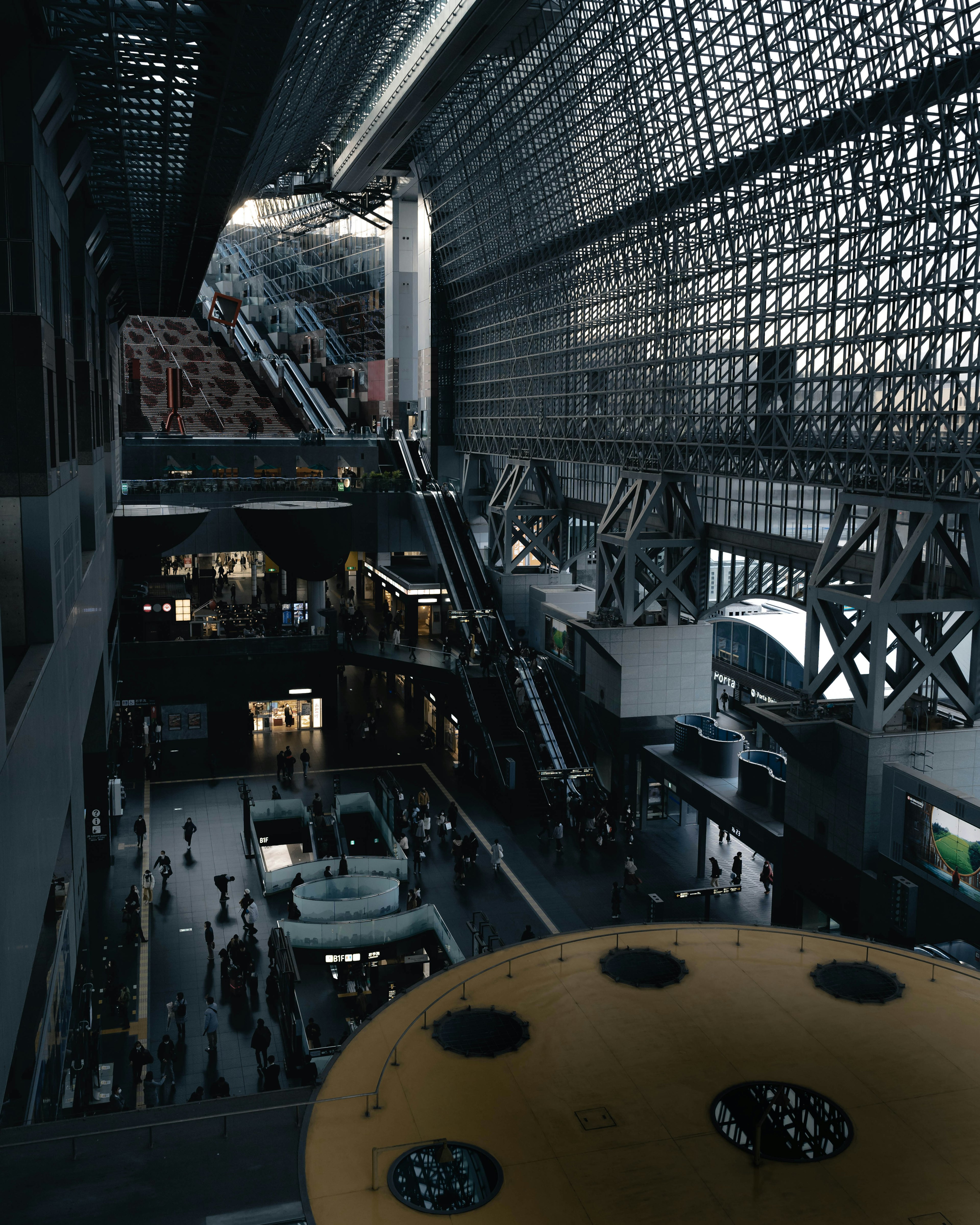 Modern architectural interior view featuring high ceilings and escalators