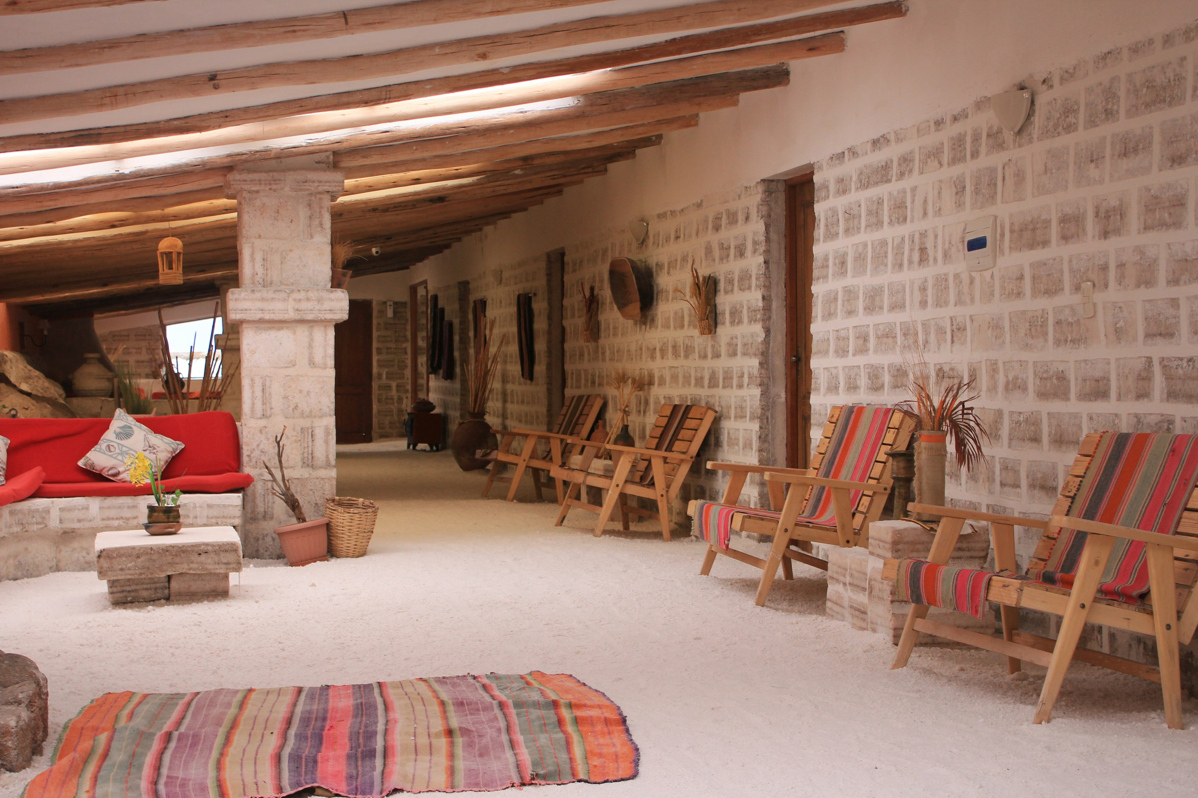 Cozy living room interior featuring a red sofa and wooden chairs