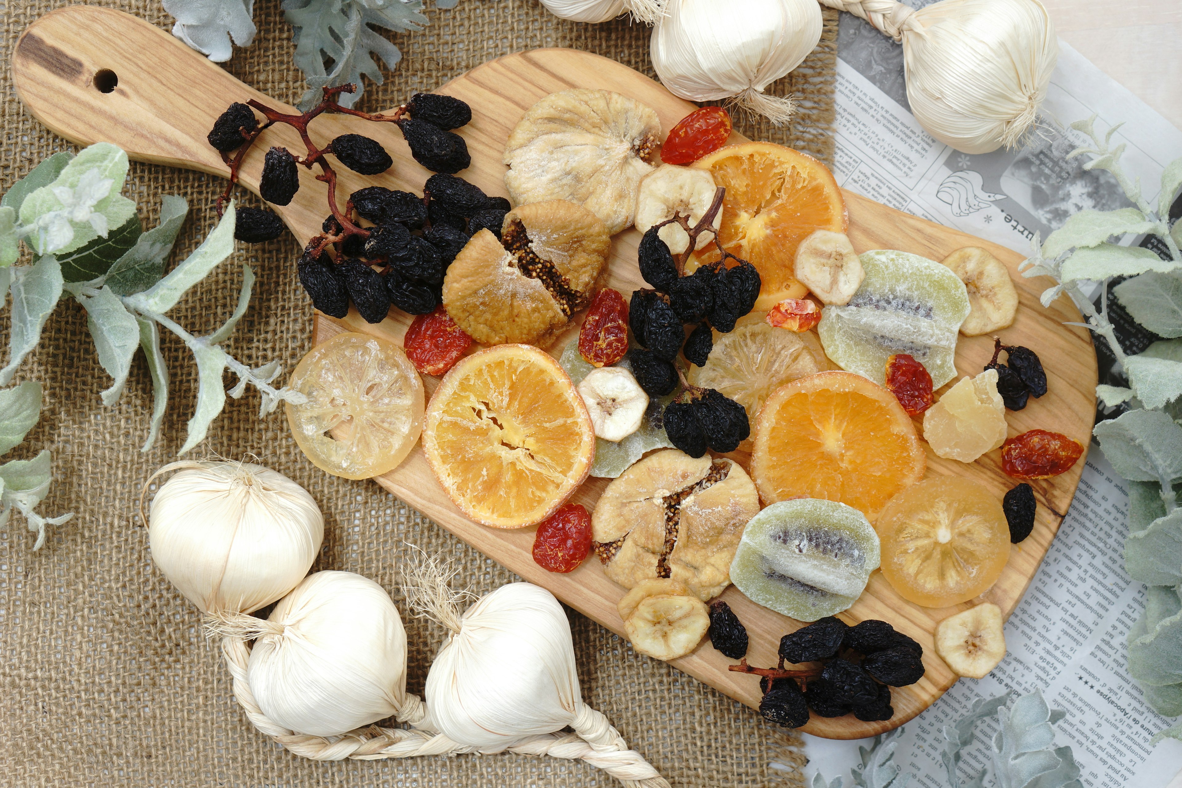 Dried fruits and garlic arranged on a wooden cutting board