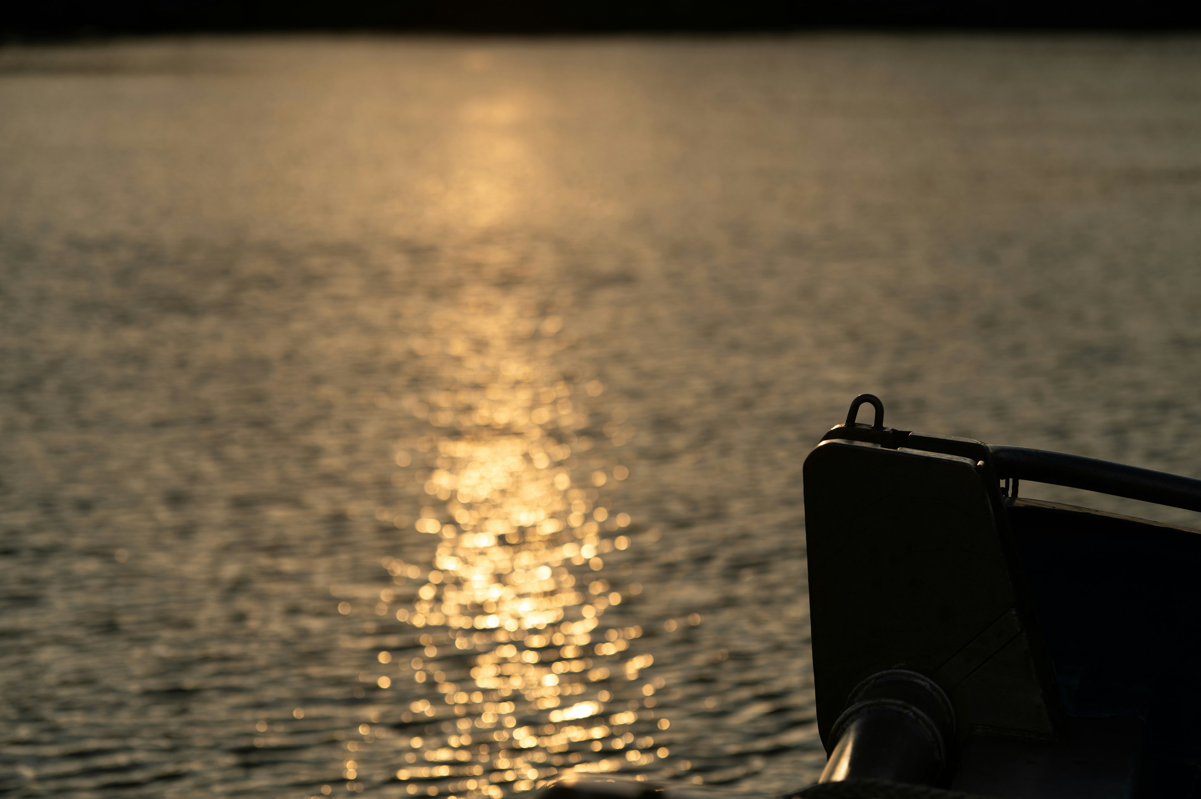 Reflexion des Sonnenuntergangs auf dem Wasser mit einem Teil eines Bootes