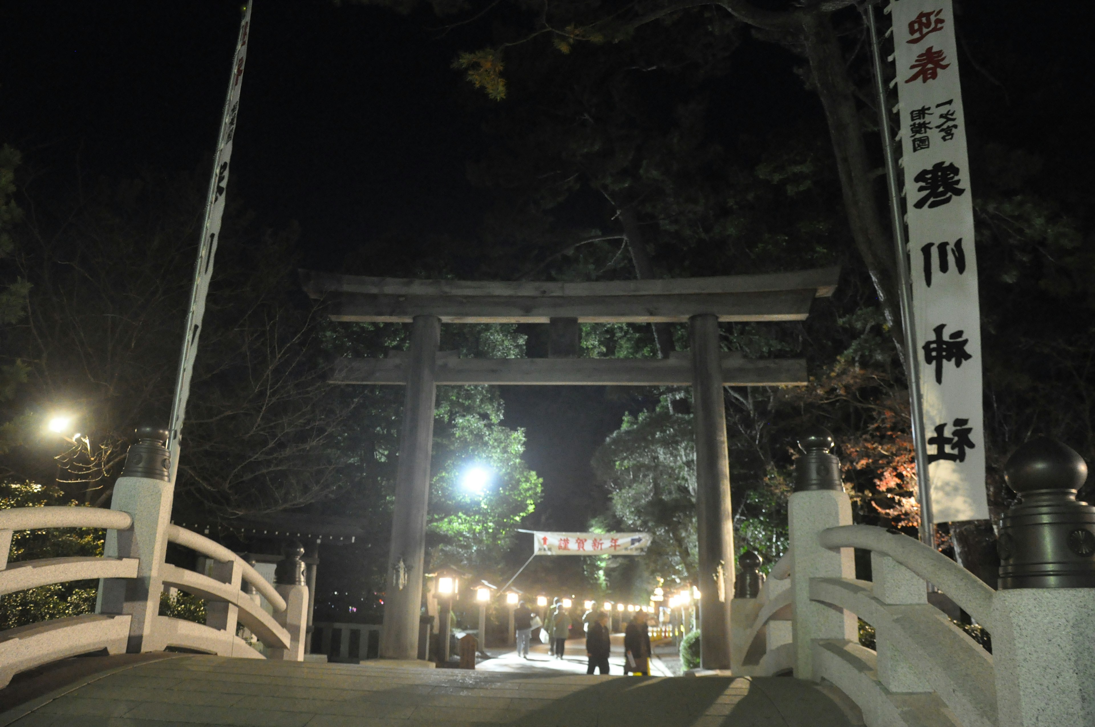 夜の鳥居と橋の風景明かりがともる道