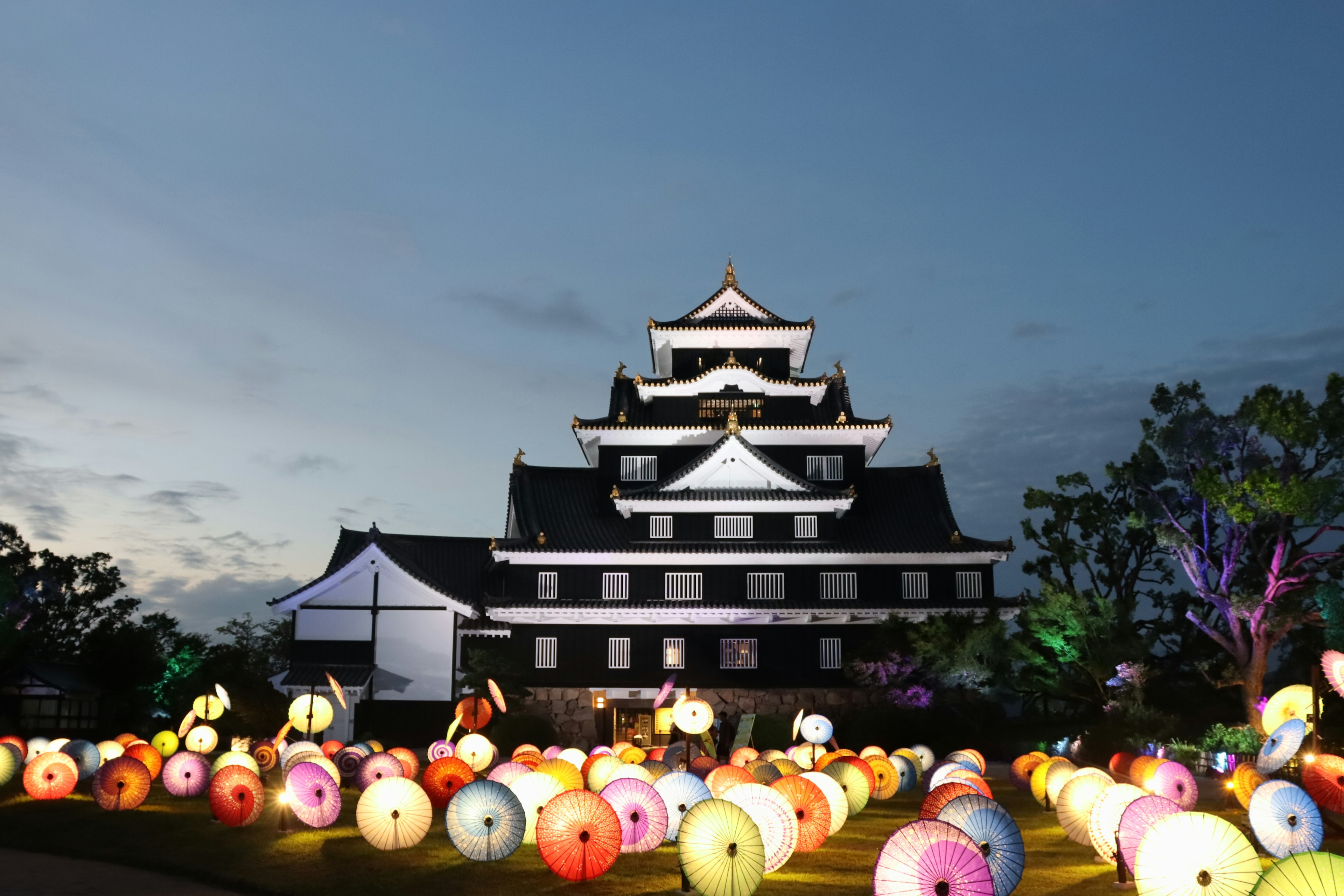 Château illuminé la nuit entouré de lanternes colorées