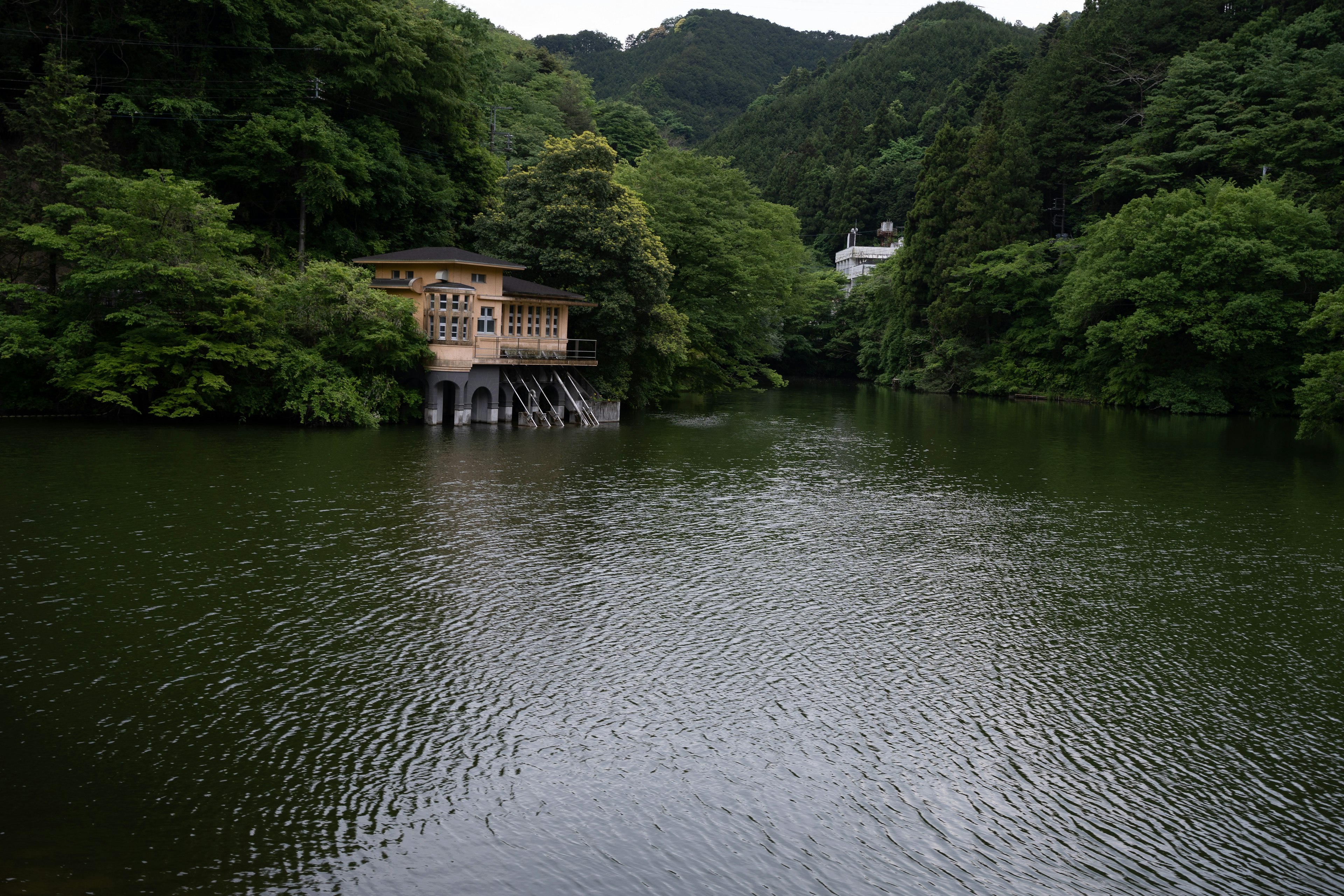 Una casa de madera en un lago tranquilo rodeado de montañas verdes