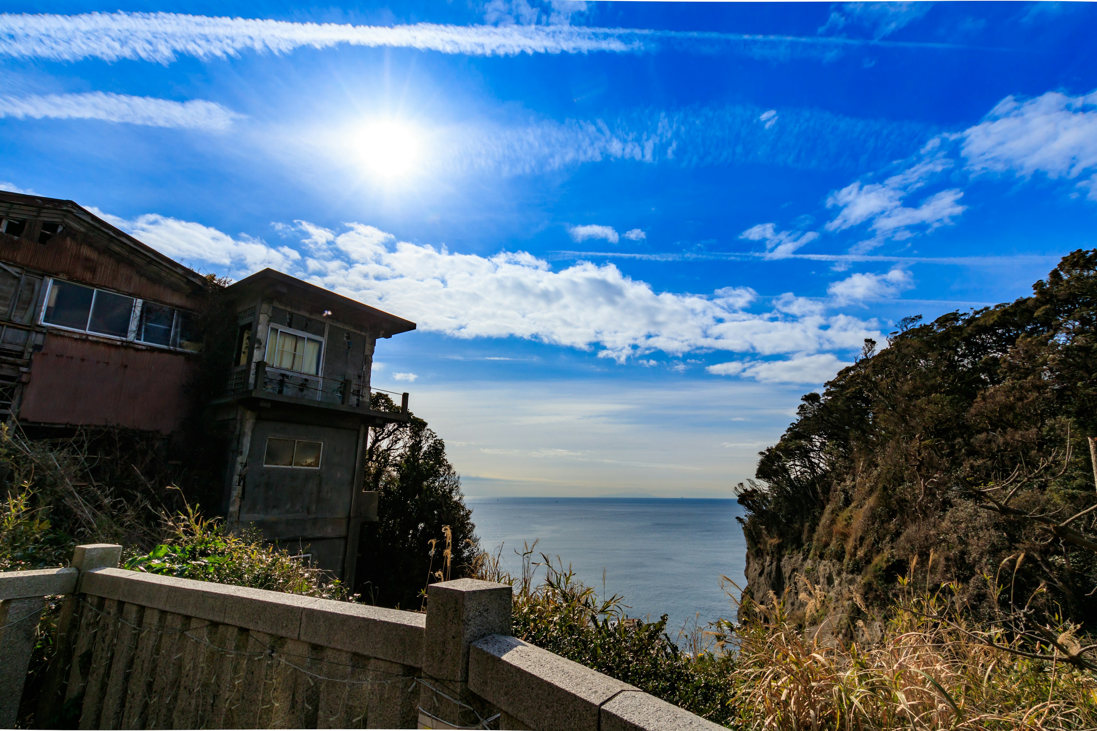 Malersiche Aussicht auf ein Haus mit Ozean- und Himmelshintergrund, blauer Himmel und Wolken