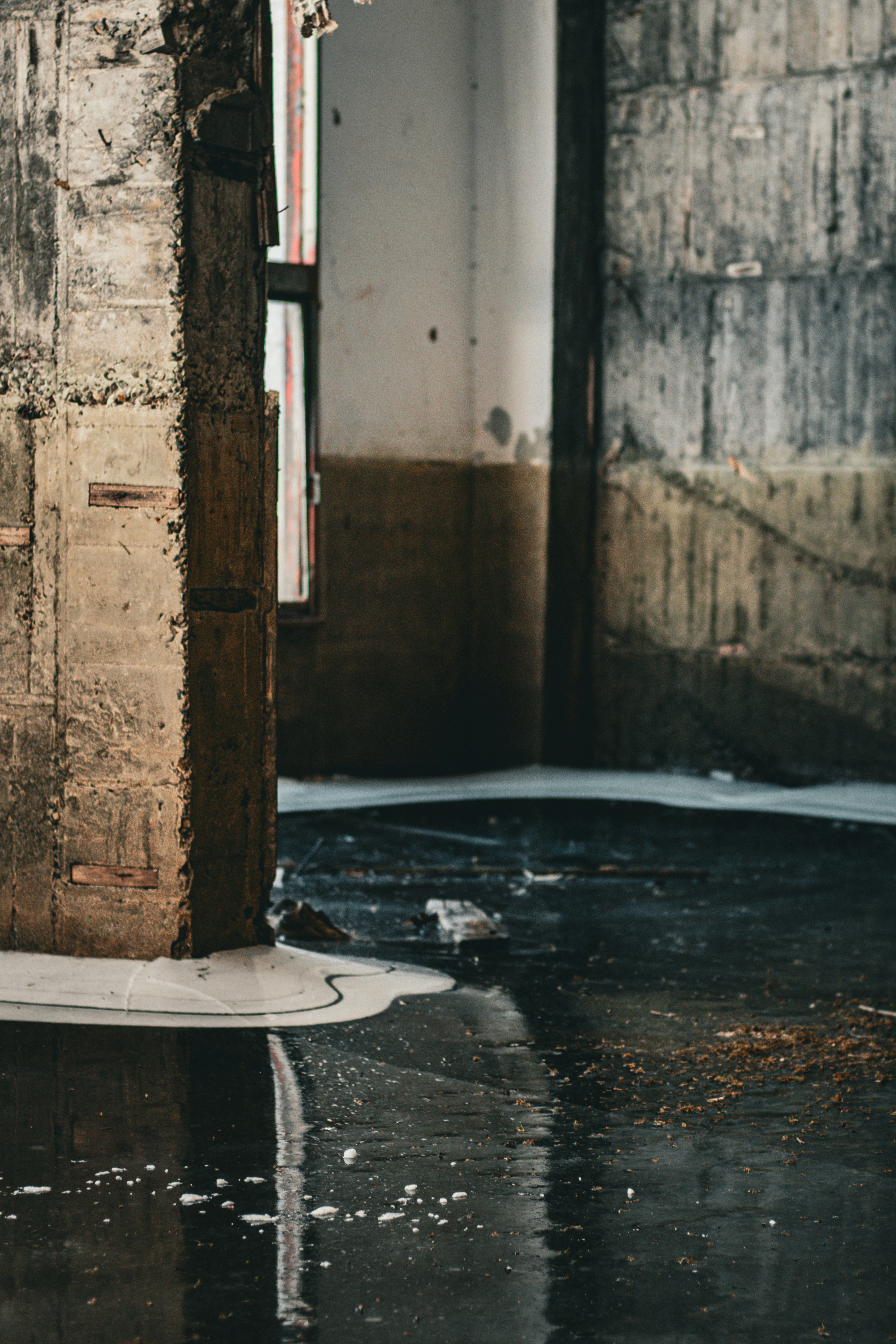 Interior of an old factory with puddles on the floor and exposed walls